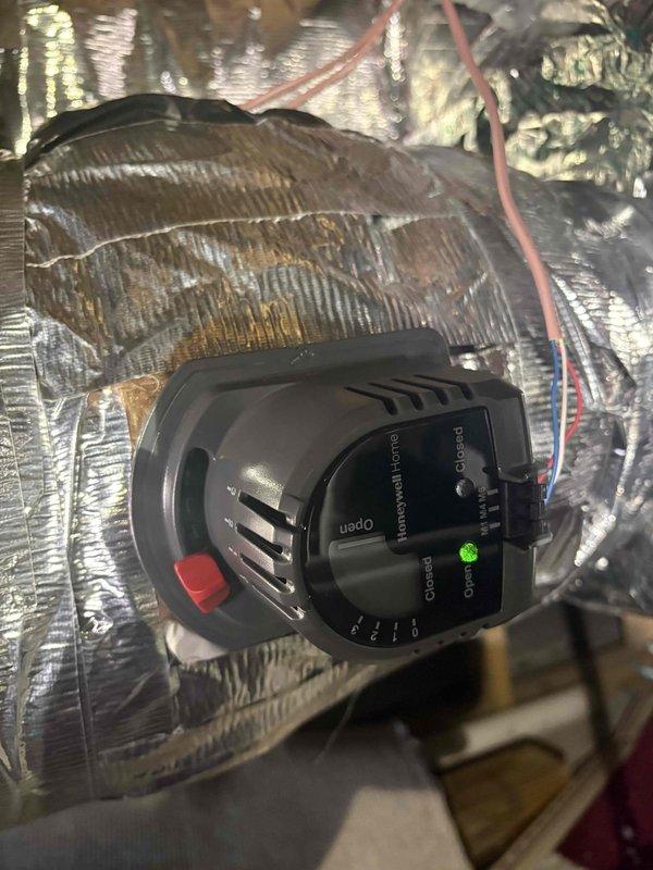 Responded to no cooling complaint where system was unable to maintain desired temperature setpoint of 76°F, with unit reading 73°F. Upon inspection, verified proper operation of recently installed automatic zone damper system including Honeywell Home motorized dampers. Confirmed damper actuators were functioning correctly with visible LED indicators and proper open/closed positioning. Instructed customer on thermostat reset procedure and verified zone control system was operating as designed for optimal temperature management throughout conditioned spaces.
