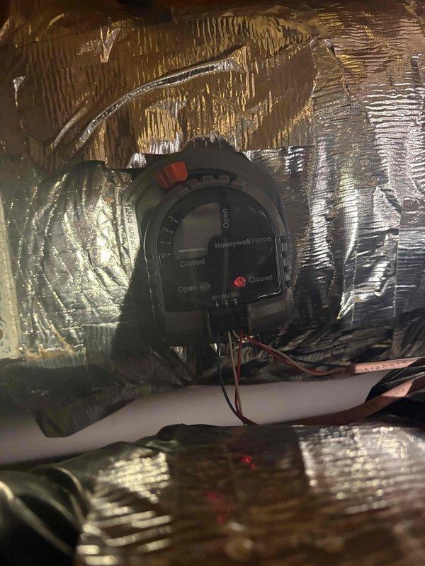 Responded to no cooling complaint where system was unable to maintain desired temperature setpoint of 76°F, with unit reading 73°F. Upon inspection, verified proper operation of recently installed automatic zone damper system including Honeywell Home motorized dampers. Confirmed damper actuators were functioning correctly with visible LED indicators and proper open/closed positioning. Instructed customer on thermostat reset procedure and verified zone control system was operating as designed for optimal temperature management throughout conditioned spaces.