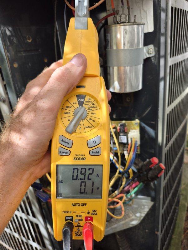 Performed preventive maintenance cooling visit on residential HVAC system. Conducted electrical diagnostics using multimeter, verifying voltage and amperage readings on condensing unit components. Inspected capacitor, wiring connections, and compressor operation. All electrical values within manufacturer specifications at 595V and 0.92A. System operating properly with no deficiencies noted.