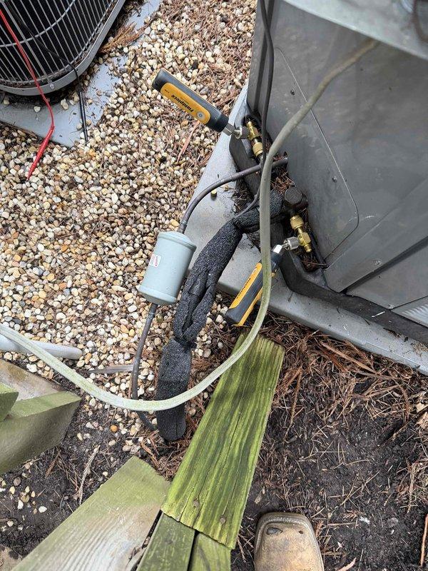 Responded to no-cooling complaint on first floor heat pump system approximately 7 years old. Upon arrival, performed diagnostic testing of outdoor unit and refrigerant system using digital gauges. Inspected condenser unit, refrigerant lines, electrical connections, and disconnect box. Evaluated system operation and assessed filtration concerns mentioned in service request. Unit found operational after inspection and testing procedures completed.