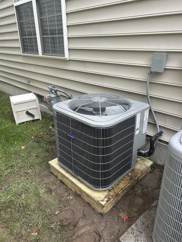 Completed full HVAC system replacement including removal and disposal of existing equipment. Installed new Carrier 27SCA518A003 1.5-ton 15 SEER heat pump outdoor unit on pressure-treated wooden platform. Mounted Carrier FJ5ANXB18L00 air handler indoors with Carrier 8kW electric heat pack. Fabricated and installed metal duct transitions to adapt new equipment to existing ductwork. Reused existing refrigerant lines and condensate drain lines where applicable. Replaced outdoor electrical disconnect and electrical whip to meet current code requirements. Installed Honeywell S1200 digital WiFi thermostat for system control. Verified all electrical connections, tested system operation through full heating and cooling cycles, and confirmed proper airflow and refrigerant charge.