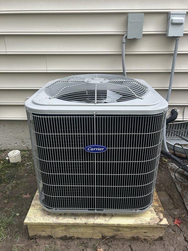 Completed full HVAC system replacement including removal and disposal of existing equipment. Installed new Carrier 27SCA518A003 1.5-ton 15 SEER heat pump outdoor unit on pressure-treated wooden platform. Mounted Carrier FJ5ANXB18L00 air handler indoors with Carrier 8kW electric heat pack. Fabricated and installed metal duct transitions to adapt new equipment to existing ductwork. Reused existing refrigerant lines and condensate drain lines where applicable. Replaced outdoor electrical disconnect and electrical whip to meet current code requirements. Installed Honeywell S1200 digital WiFi thermostat for system control. Verified all electrical connections, tested system operation through full heating and cooling cycles, and confirmed proper airflow and refrigerant charge.