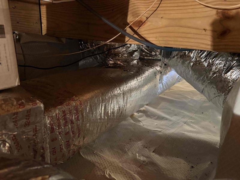 Diagnosed residential HVAC system in crawl space and identified failed blower motor and low-pressure switch requiring replacement. Provided comprehensive equipment replacement estimate as alternative solution, documenting existing air handler unit with copper refrigerant lines, condensate drain system with pump, and flexible ductwork installation. Recorded model and serial numbers for pricing comparison between component repair and full system replacement options.