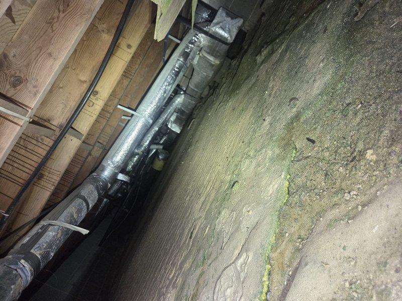 Completed comprehensive heating system maintenance inspection in residential property. Inspected HVAC ductwork system located in attic and basement areas, including insulated supply ducts with reflective wrap material and refrigerant line runs. Documented condition of air distribution components and identified moisture concerns on foundation wall near mechanical equipment requiring future attention.