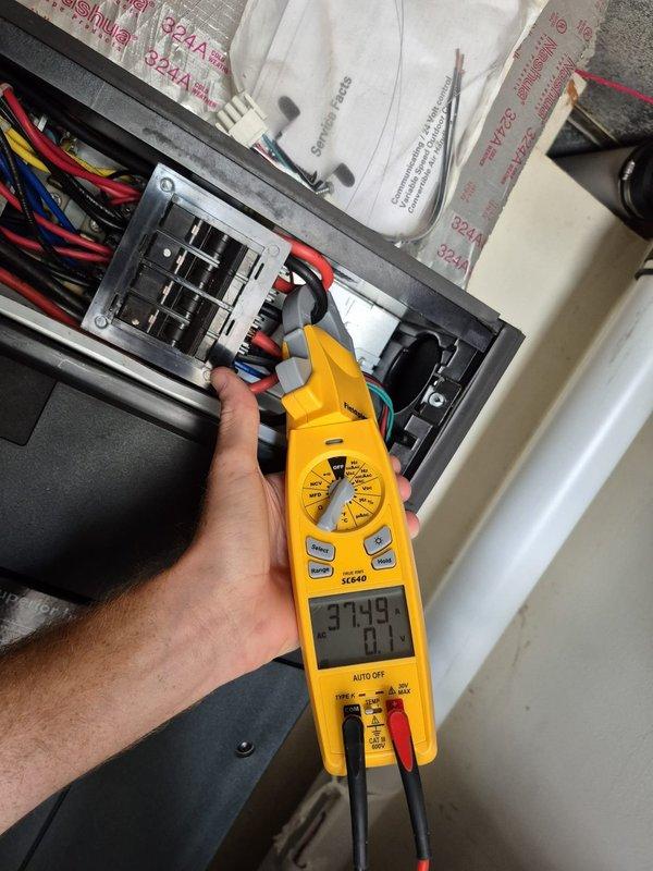 Completed recurring heating maintenance visit and system diagnostics. Verified thermostat operation showing proper heating mode at 70°F setpoint with fan in auto mode. Performed electrical measurements at the system panel using clamp meter, recording amperage draw of 37.49A with minimal variance, confirming normal operating parameters for the heating equipment.