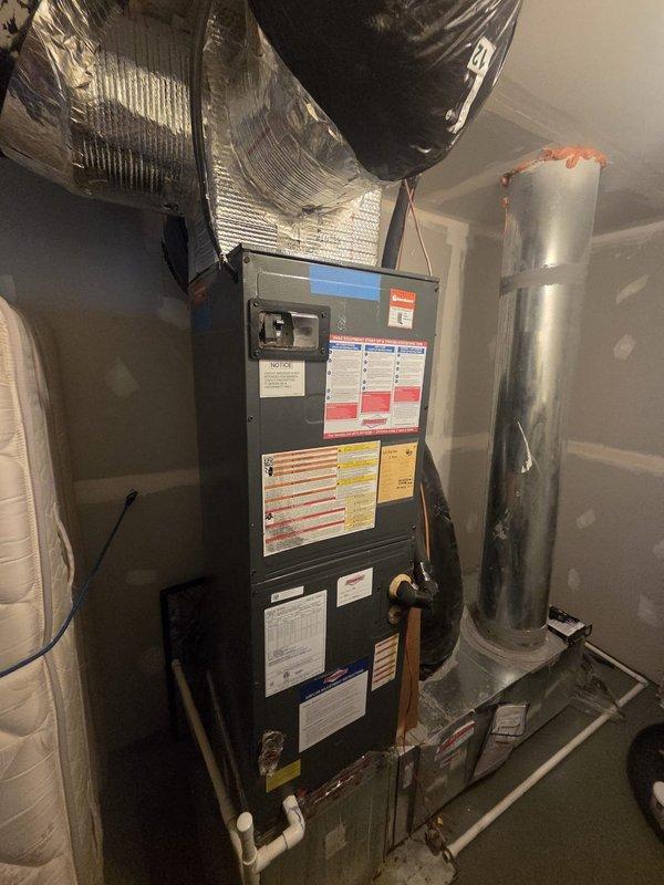 Performed scheduled seasonal heating maintenance on a vertical air handler located in an interior utility closet, inspecting the cabinet, supply plenum, and flexible ductwork connections and verifying the condensate drain piping and sealed duct joints. Access to the unit was limited by stored items in the closet, and the system was cleared for operation with no deficiencies noted.