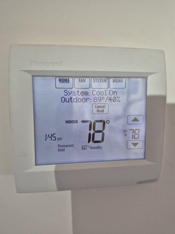 Performed scheduled heating maintenance inspection on two systems and verified thermostat operation and system controls, with the thermostat in a permanent hold at a 78° setpoint and the system in cool mode at the time of visit. Measured electrical load with a clamp meter, recording approximately 41.9 amps AC at the electrical disconnect, and inspected the surrounding ductwork, condensate piping, and wiring for damage, with no anomalies found.