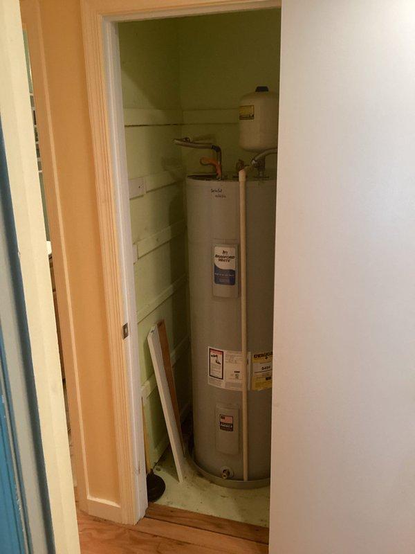 Removed the leaking water heater and installed a new 50-gallon tall Bradford White tank-type unit. Installed a new drain pan, thermal expansion tank, brass nipples, tee, and fittings, and connected the water lines with 18" flexible connectors. Verified all connections are secure with no leaks and the unit is operating properly.