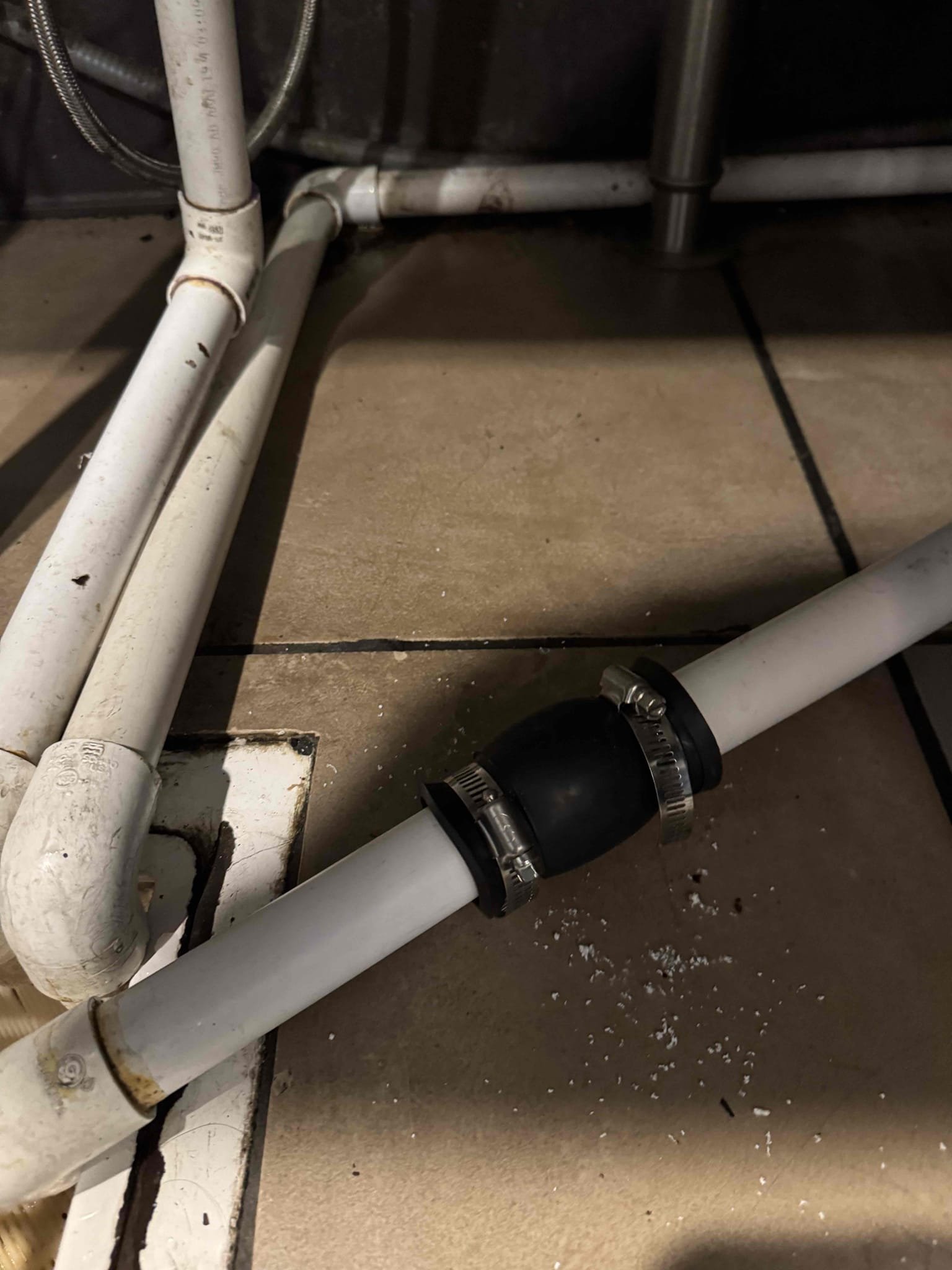 Upon inspection, the drain line for the ice bin was found to be improperly positioned, lying on the floor instead of draining into the floor sink. To rectify this, I extended the drain pipe to ensure it reaches the sink properly. Additionally, I incorporated a flexible section using a 1-1 1/4 inch Fernco coupling, which allows for movement and prevents breakage during cleaning. This modification ensures the drain line will function correctly and remain intact. The work was completed efficiently, and I signed for Eric to confirm the job's completion.