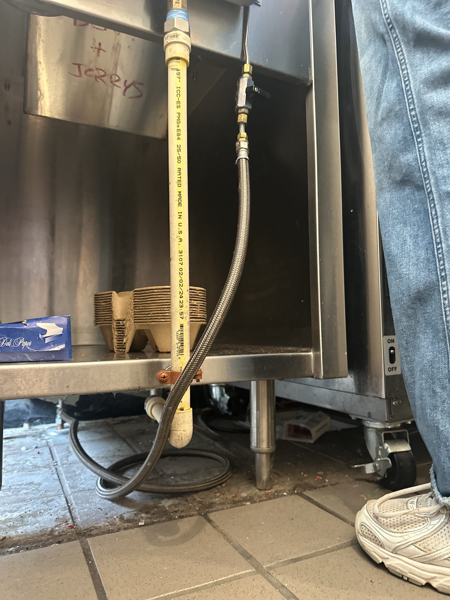 Upon arrival, I inspected the drain for the dipper well faucet, which was connected to a 3/4” CPVC line and a 3/8” supply line. The constant clogging issue was addressed by removing the supply line and adapter. I then installed CPVC piping all the way to the floor sink under the left freezer. The drain was secured, and I ensured the freezer was positioned correctly. The drain is now functioning properly. Parts used included three 3/4” 90-degree CPVC elbows, one 3/4” CPVC coupler, Flo guard CPVC glue, and two 3/4” 2-hole straps.