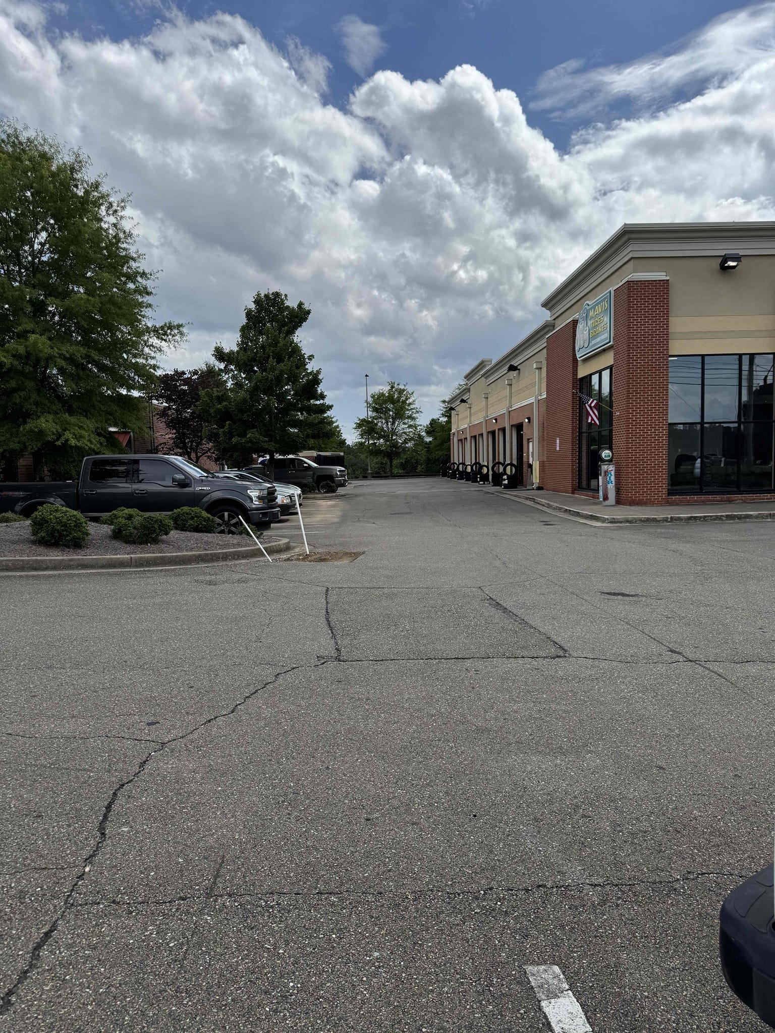 Upon inspection, a water leak was identified originating from the main water line. The leak was located halfway down the parking lot, where water was seeping through the asphalt. The 2” PVC pipe, extending 225 feet from the meter to the pressure-reducing valve (PRV), was inspected. The clean-out was found ten feet from the leak. The irrigation system was confirmed to be off, as per the manager. The water line to the irrigation was also checked and found to be disconnected. The 2” PVC pipe emerged from the ground, connecting to a 1 1/2” Watts PRV. Water supply to the store had been turned off for three days.