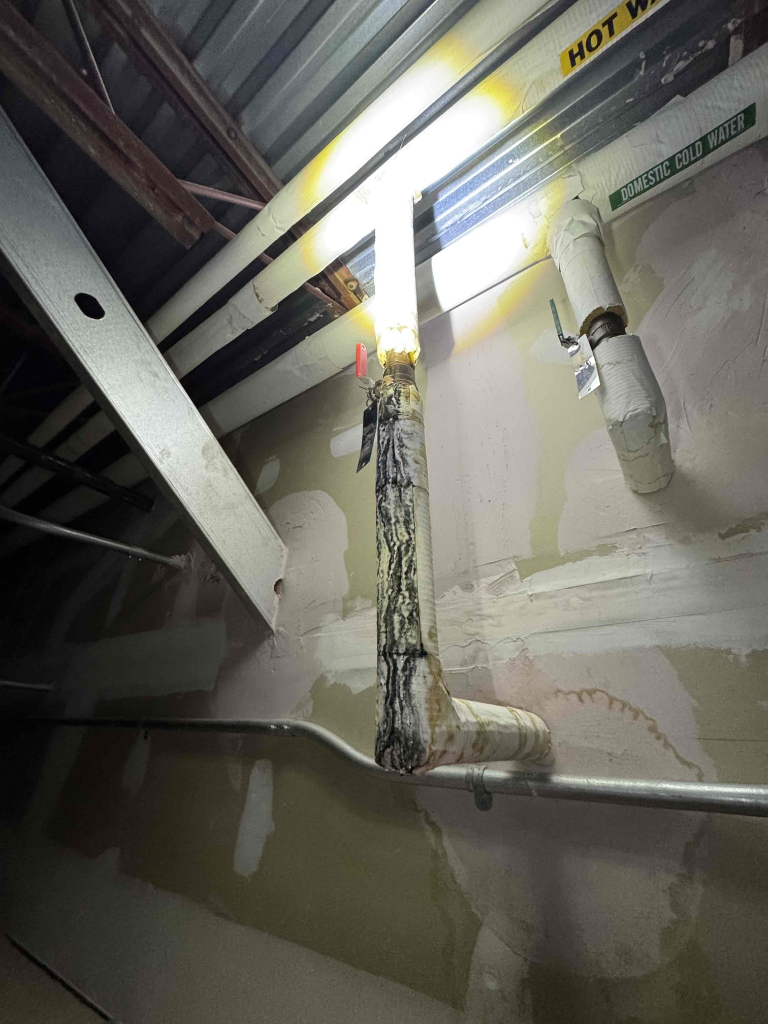 On 7/15, I inspected the affected area and identified a 1-inch pipe with electrolysis, approximately 30 feet long, and two visible drips. The insulation showed bad areas, and the pipe transitioned to a 3/4-inch line via a tee to a ball valve. The tee was in good condition. Additionally, a 2 1/2-inch pipe around an HVAC duct had electrolysis and a leak at a 90-degree bend. I returned with parts and completed the repairs on 7/20, using specified copper pipes and fittings.