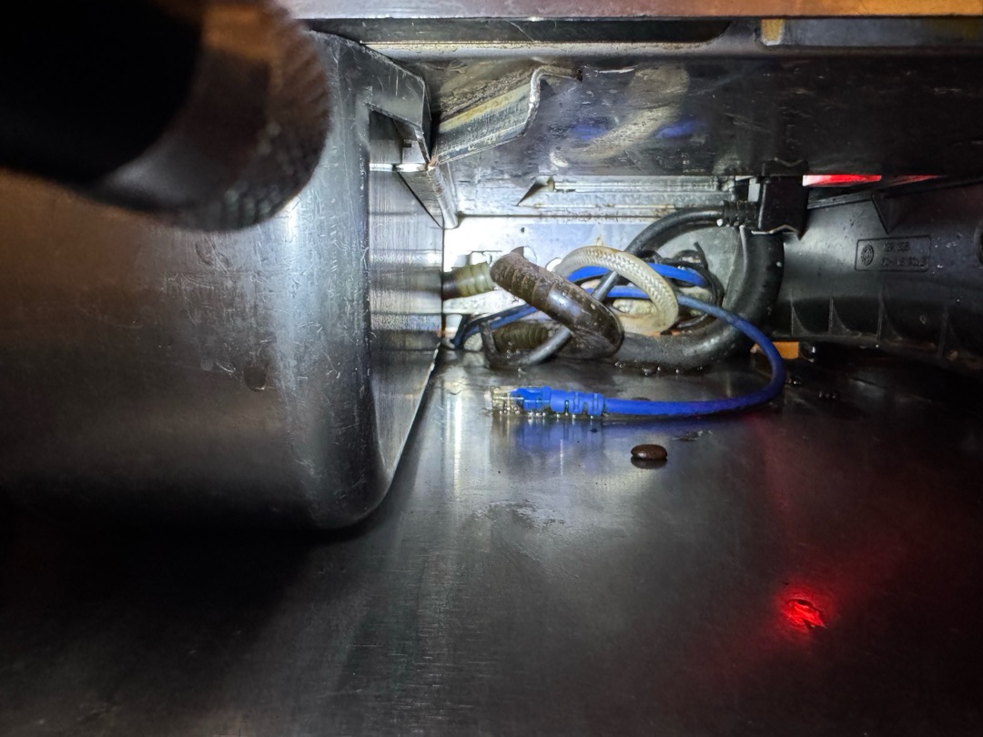 Upon inspection, the drain tray for the espresso machine at the bar had a rubber tube that was disconnected from the other drain parts. To prevent leakage, I reconnected the tube temporarily. The rubber tubing will need to be replaced by the specialized espresso machine technician. I ensured the temporary fix would not cause any leaks, and the store manager will contact the appropriate technician for the replacement. The job was signed off by Jay.