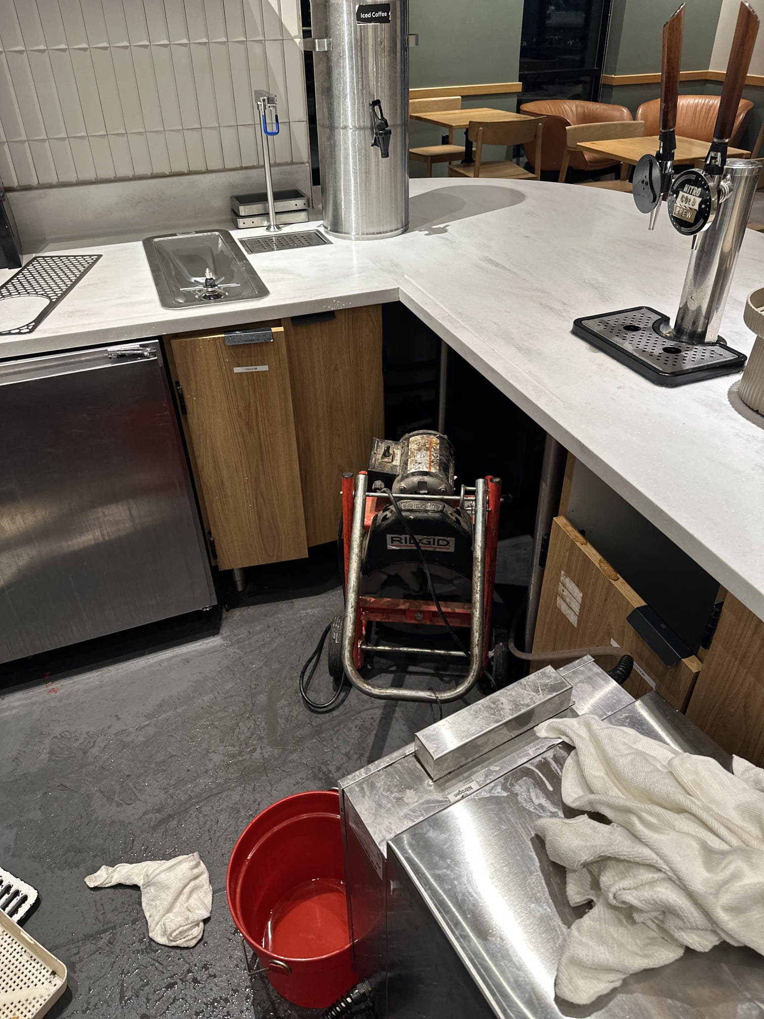Upon arrival, I inspected the floor sink under the hand-off counter, which was clogged and holding water. I began by using a small auger to attempt to dislodge the clog, but it was too deep. Next, I employed a small machine to reach the blockage, which was located approximately 25 feet down. After successfully hitting the clog, I pushed the cable all the way out and then pulled it back. To ensure the clog was completely removed, I flushed the sink with several buckets of hot water, which flowed freely without any issues. The floor sink is now clear and functioning properly.