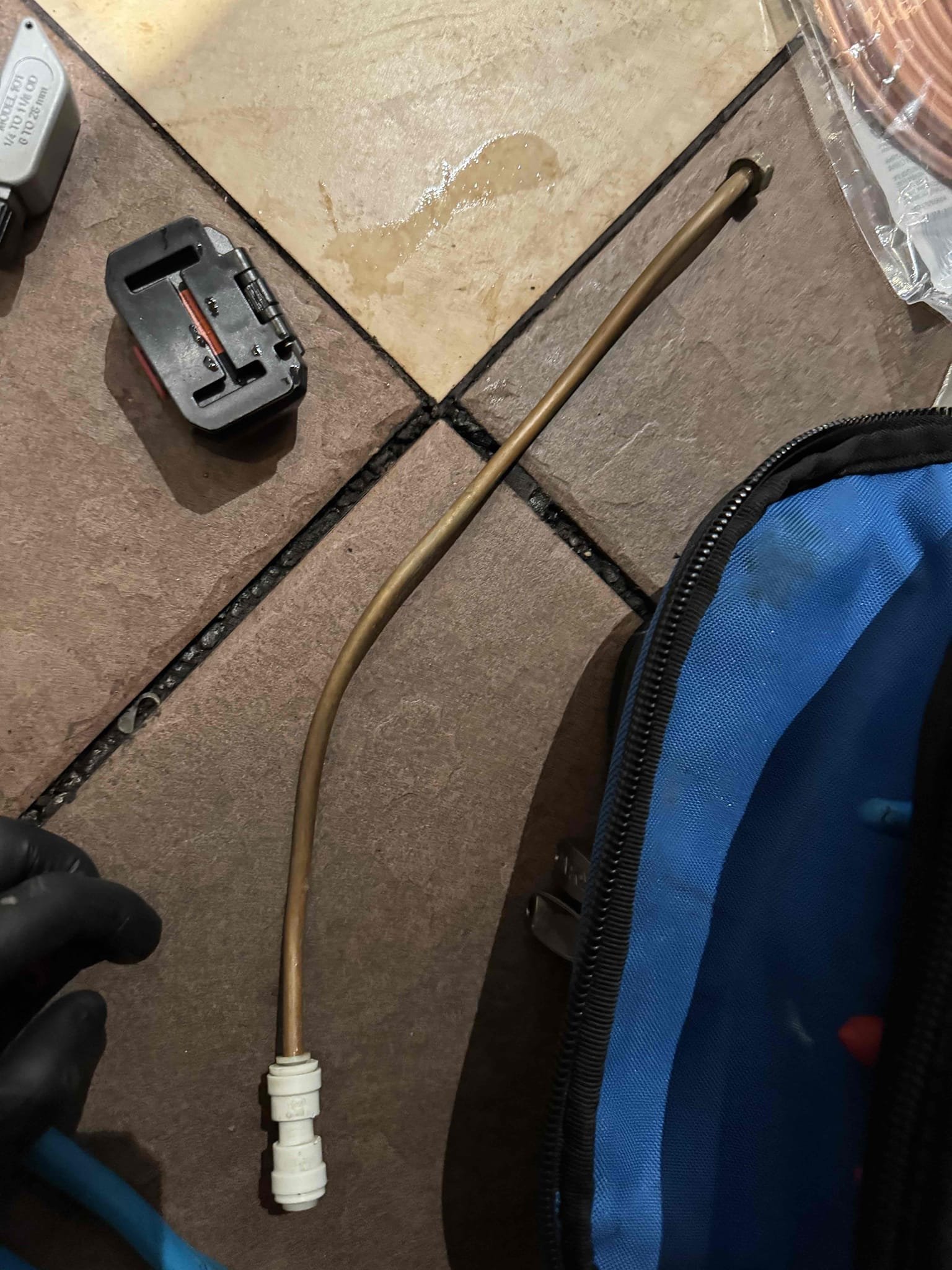 Upon inspection, I identified a pinhole leak in the 1/4” copper tubing connected to the faucet. I promptly turned off the water supply and sourced the necessary replacement parts. After removing the damaged section, I installed a new piece of 1/4” copper tubing, ensuring a secure connection with a brass compression coupler. I applied lock tite to the lock nut and adjusted it to the correct tightness. Following the repair, I turned the water supply back on and verified there were no leaks. Additionally, I secured the dishwasher dump line to the ice maker drain line using zip ties.
