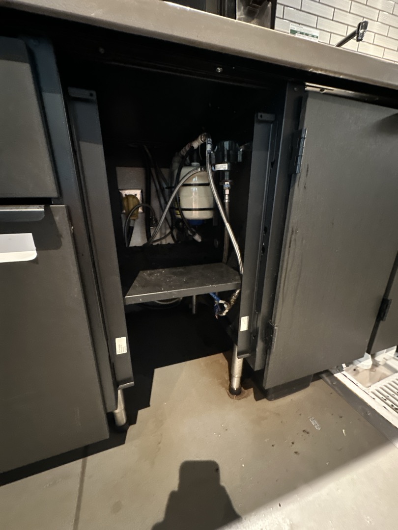 Upon arrival, I inspected the area under the Vertica machine. After shutting off the water supply to the machine, I turned the water back on. Immediately, water began spraying from the top of the valve box. I informed Manager Lacy about the issue and recommended that a work order be submitted for a Vertica technician to address and repair the problem.