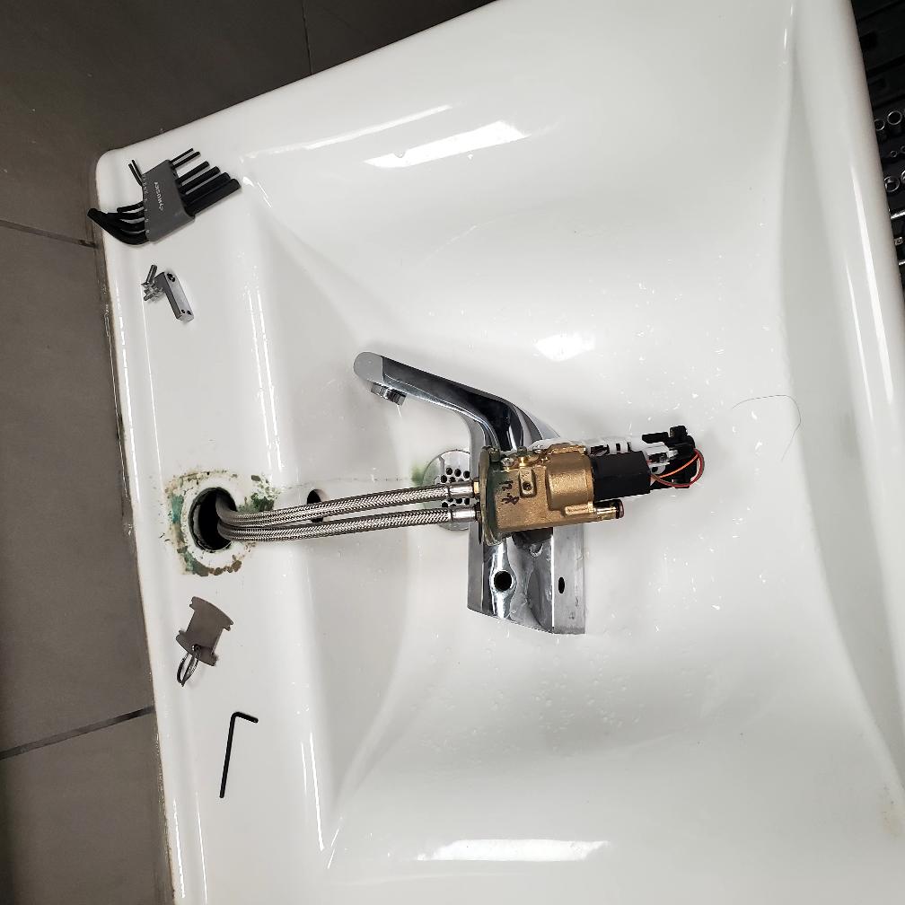 On the specified date, I addressed issues with both hand sink faucets, which were producing water from a 0.5 aerator on a sensor with a mixing valve underneath each sink. The water heater and recirculating pump were found in the mop closet, but the pump was not functioning. The thermostat sensor was staged on the hot line and had never turned on because the pipe temperature was consistently above the cycle temperature. I corrected this by moving the thermostat wire to the mixed line. Additionally, the faucets lacked sufficient pull at 0.5 gpm, causing the mixing valve to be set too low. After adjustments, the temperature was restored to proper levels. The first restroom faucet was leaking from the spout at all times, requiring disassembly and cleaning of the solenoid to restore functionality.
