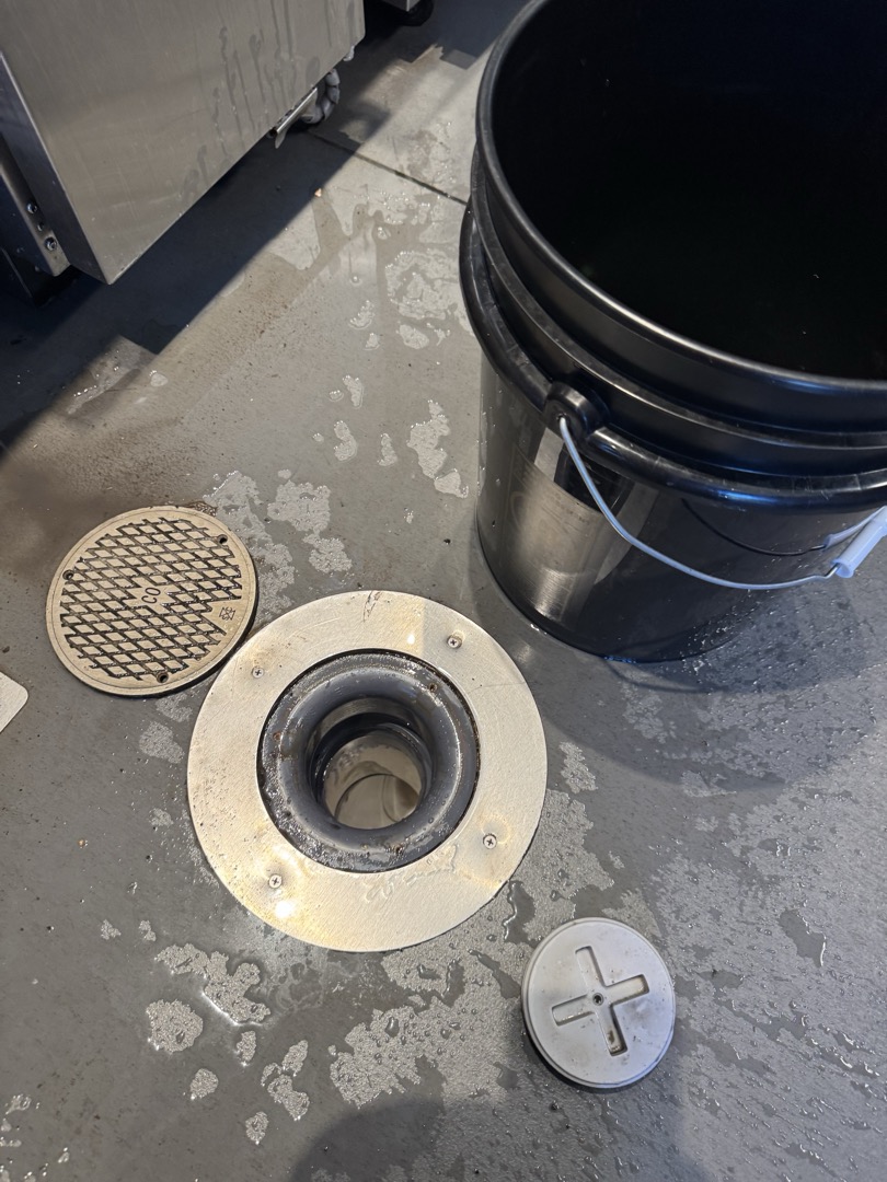 Upon arrival, I identified a clog in the drain line from the cold bar. I accessed the clean-out point and used a mechanical device to dislodge the obstruction. After successfully clearing the clog, I ran the machine further to ensure the line was fully open. To confirm the line's patency, I flushed it with multiple buckets of hot water. I advised the team to run hot water while cleaning the dump sink to prevent future buildup. Post-completion, I cleaned up any mess created during the process. The job was signed off by Ryan.