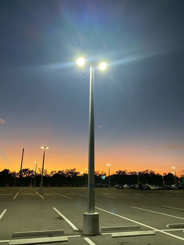 Installing LED parking lot light fixture using bucket truck