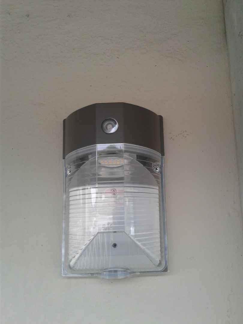 Commercial electrician fixture replacement - Installing small LED wall pack with photocell for our Sunset Place customer.