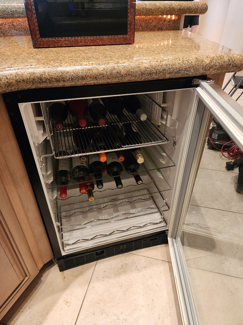 Upon inspection of the GE Monogram under-counter wine storage unit, it was determined that the cooling performance was suboptimal. A thorough examination of the condenser coil revealed it was covered in dust and debris, which can impede cooling efficiency. I meticulously cleaned the condenser coil using a vacuum and brush to remove all accumulated dirt and grime. Additionally, I inspected the door seals for any signs of wear or gaps that could allow warm air to enter, ensuring they were intact and sealing properly. The overall health of the unit was assessed, and necessary adjustments were made to restore optimal cooling performance. The wine storage unit is now functioning as intended, maintaining the ideal temperature for wine preservation.