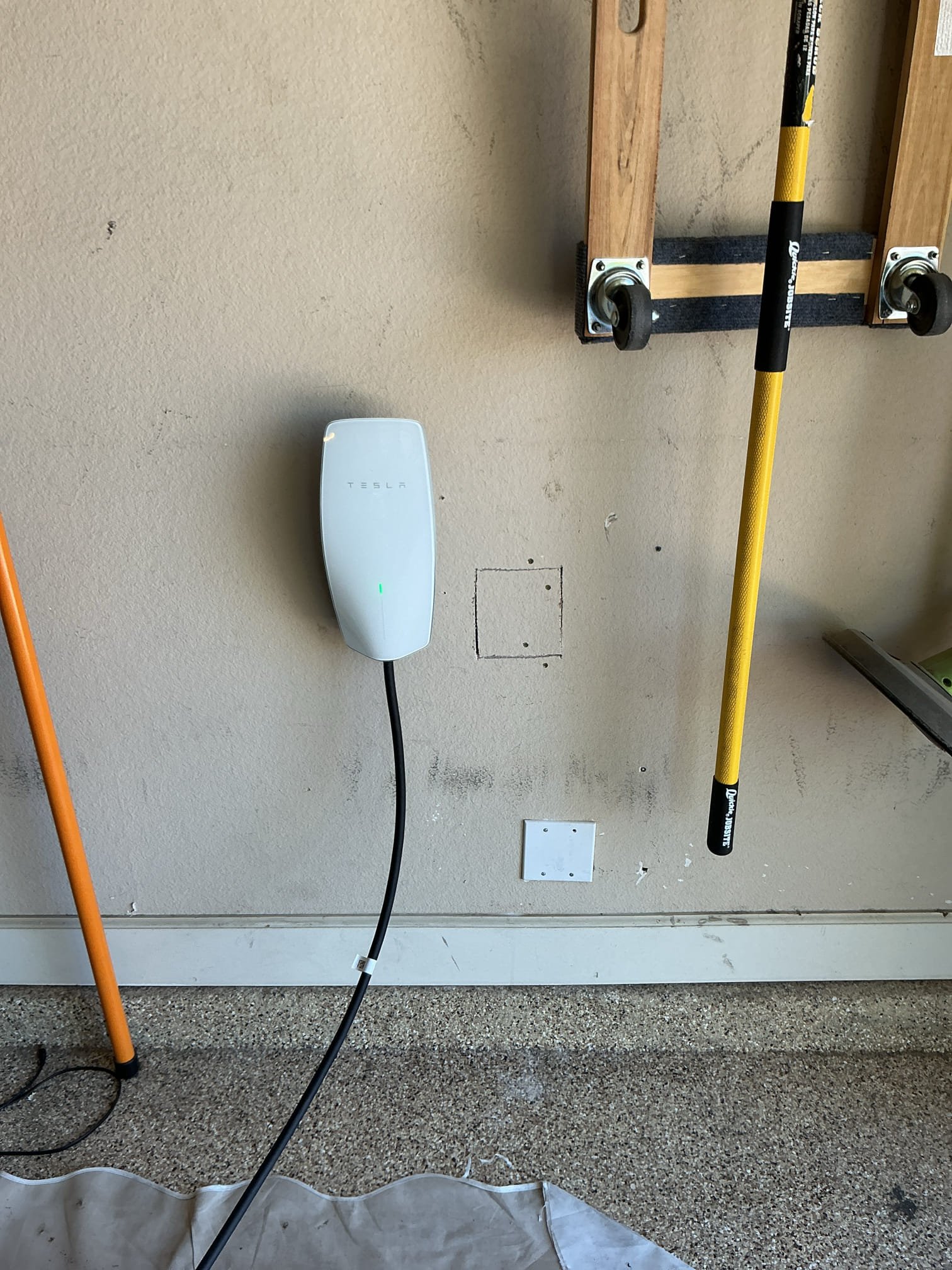 arrived to install a Tesla Car Charger in garage near panel. Installed charger on stud next to panel, had to cut drywall in order to pop out knock out I’m panel and run wires for charger. Installed a breaker. 