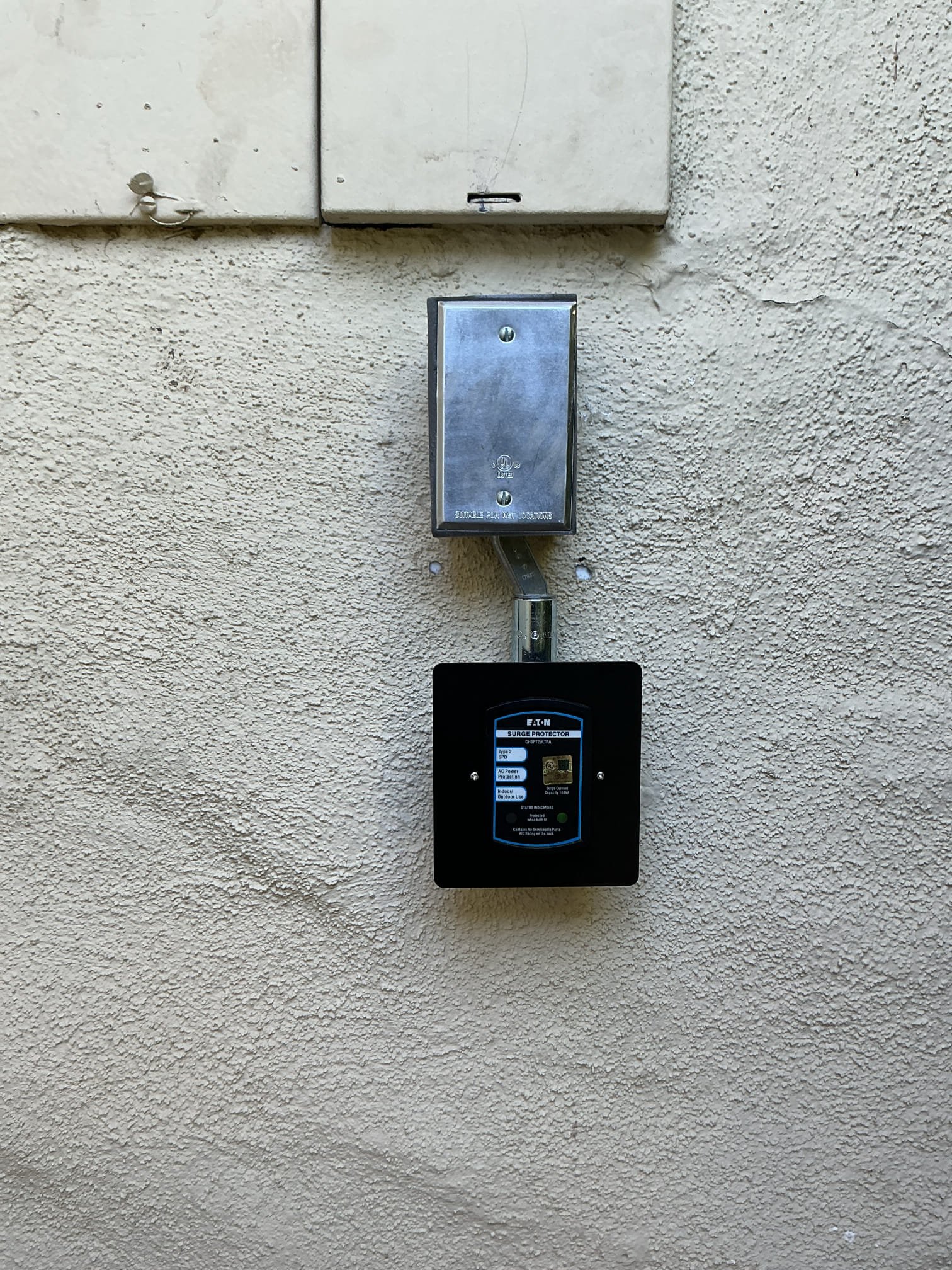 Arrived to install a surge protector cover plate and redo silicone around weather rated box. Removed as much of the previous silicone off the wall box and surge protector. Reinstalled box and surge protector. Applied silicone around weather rated box and installed cover plate on surge protector.
