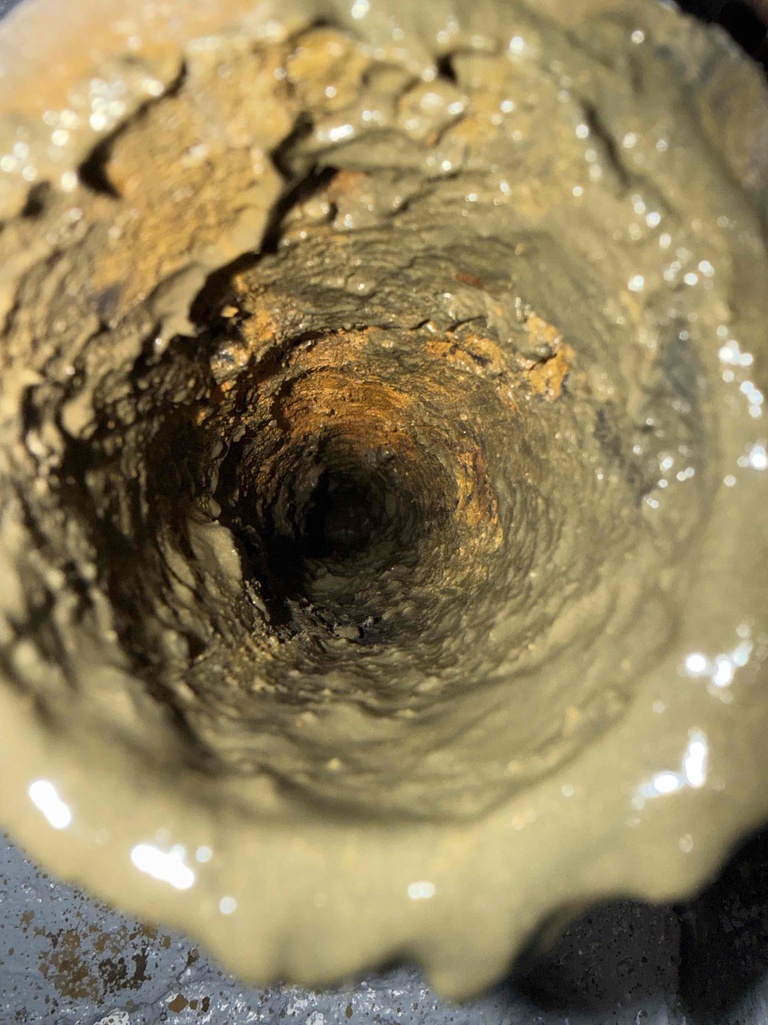 Homeowner stated that he ran two short cycles on the washer and it drained fine but then he ran a longer cycle with more water and it started flooding the laundry room so he called us to fix the issue. Upon arrival homeowner greeted me at door and showed me to the laundry room and I could smell sewer odor and homeowner explained the situation. I offered a couple of solutions and he opted to replace the cast iron and install a p trap. I started on first floor and cut the wall and there was no p trap so I removed two 90 2 inch elbows and cut the cast iron lower and installed a sanitary tee 2 inch with a p trap and a studor vent. Once I was done I proceeded to the basement and began removing the cast iron for the laundry line and upon removing it the pipe was full of black sludge that solidified so I ran my flex shaft and removed all the sludge and ran water and it works properly I connected the 2 inch to 3 inch pvc and then tested the connections. It all works properly and homeowner is s