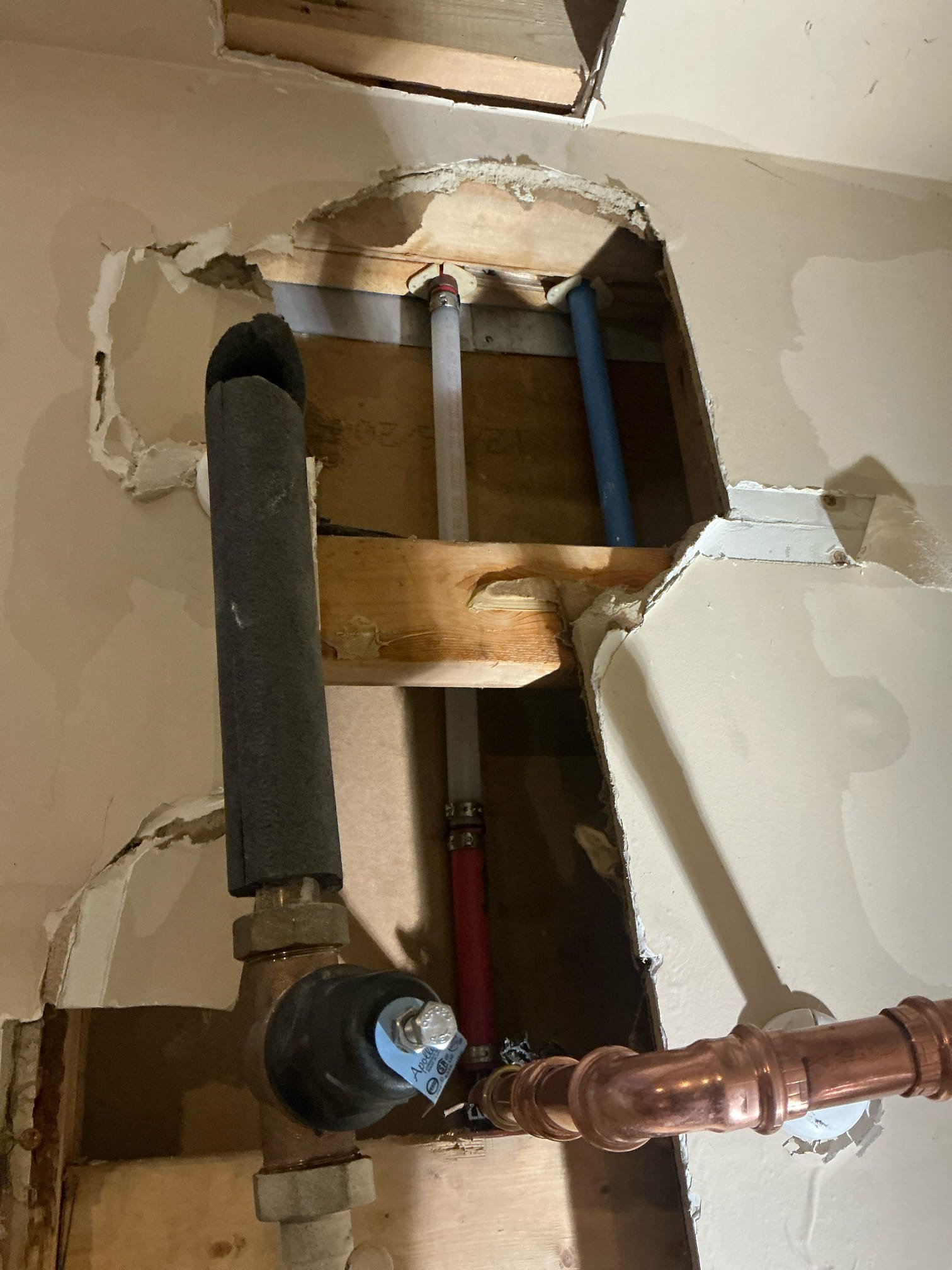 Client called us out today due to a water line leak inside the garage just above the water heater in the wall. It had caused a good bit of water damage in garage and to the inside pantry area as well. Referred reliable restoration to assess and deal with the water cleanup and put back. Due to the location of the leak, I had to uninstall the water heater to get access to the pipe in order to make the repair. Uninstalled the 2 yr old water heater then found a split 3/4” hot pex line just before it went up into the attic to feed rest of home. This is second leak on this same section of piping. This time, there was a split in the pipe about 2” long water was spraying out of. Removed tang section and repaired with a couple fittings and some pex a water piping. Before installing water heater back we tested for Leaks, there are none. Proceeded to reinstall the water heater and added new ball valve shutoff and new properly supported thermal expansion tank per code, as the previous install was 