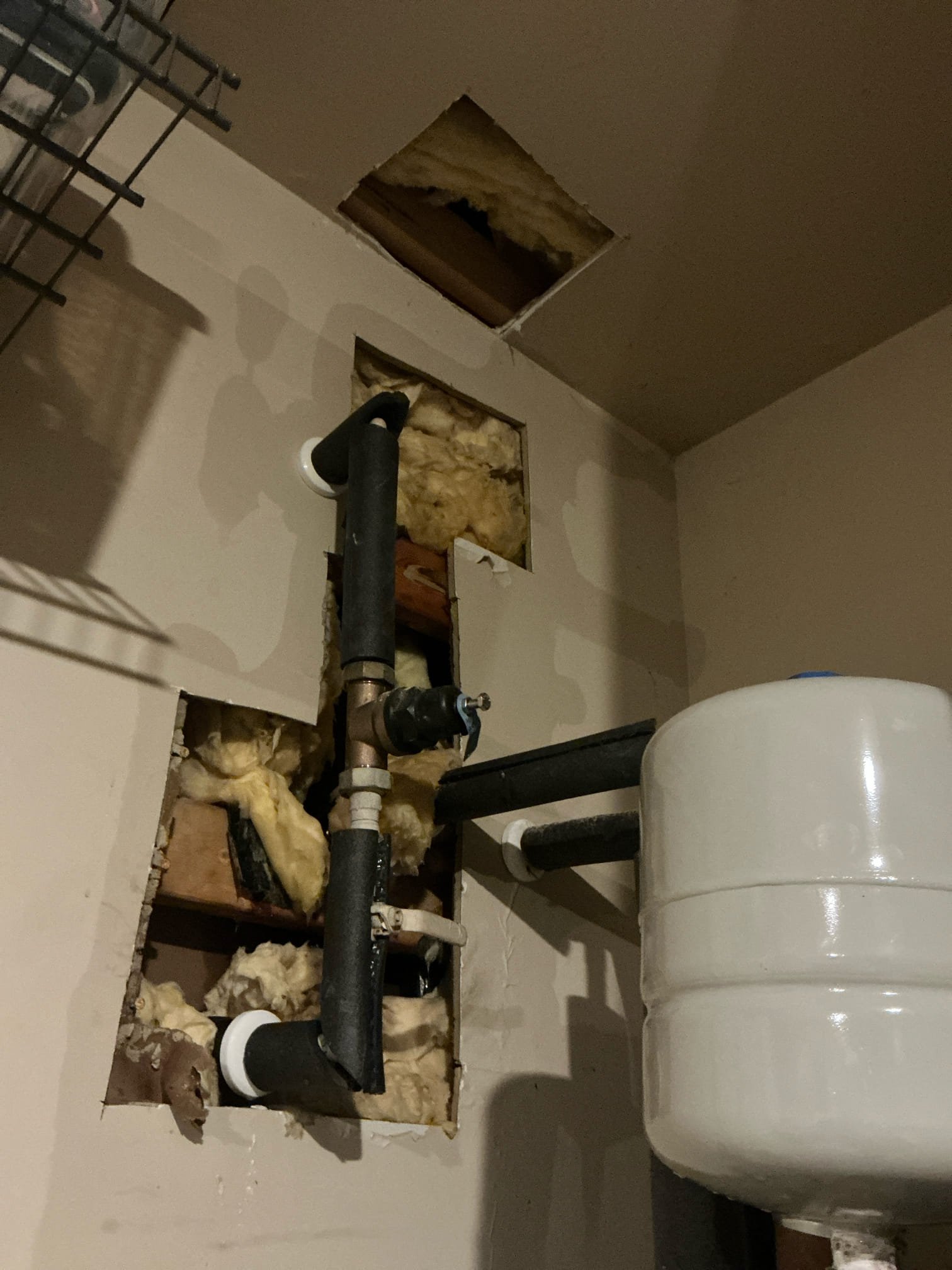 Client called us out today due to a water line leak inside the garage just above the water heater in the wall. It had caused a good bit of water damage in garage and to the inside pantry area as well. Referred reliable restoration to assess and deal with the water cleanup and put back. Due to the location of the leak, I had to uninstall the water heater to get access to the pipe in order to make the repair. Uninstalled the 2 yr old water heater then found a split 3/4” hot pex line just before it went up into the attic to feed rest of home. This is second leak on this same section of piping. This time, there was a split in the pipe about 2” long water was spraying out of. Removed tang section and repaired with a couple fittings and some pex a water piping. Before installing water heater back we tested for Leaks, there are none. Proceeded to reinstall the water heater and added new ball valve shutoff and new properly supported thermal expansion tank per code, as the previous install was 