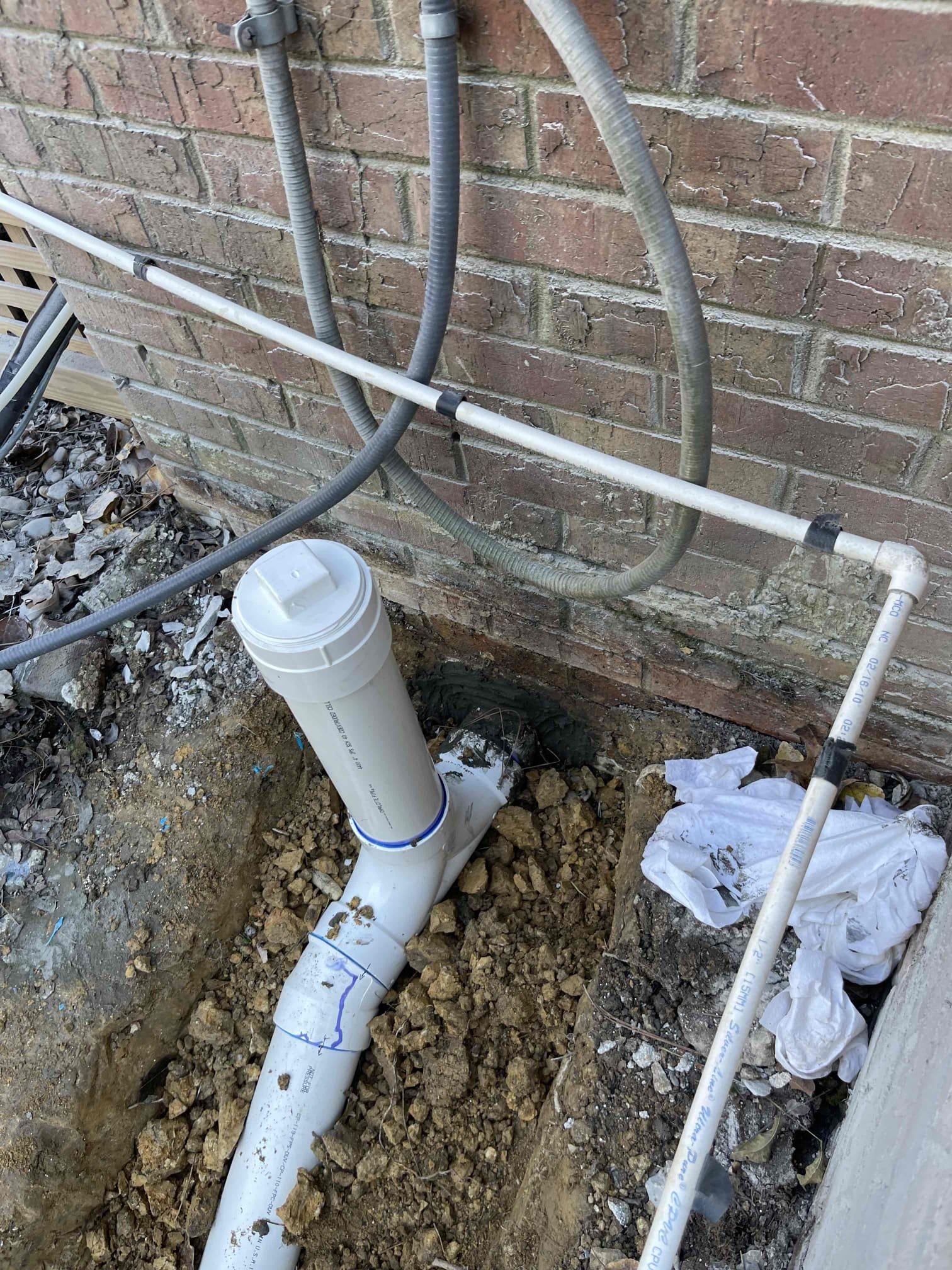 Came out to perform work as quoted. Cut out 30’ drain piping inside the basement. Dug up the first 15’ of drain piping outside. We found there was a cleanout installed that was original to the home. Where 5e cap was coming up to the ground level, there was a slab of concrete poured over it for the hvac condensor. Weight of the concrete pushed down on the pipe over 5e years and cracked the abs and caused a belly under the condensor slab. We replaced pipe coming back through the wall. Installed new two way cleanout by the foundation wall. Backfilled and bedded pipe. Sealed foundation with hydraulic cement. Tested to ensure a leak free installation. No further issue at this time. 2 year warranty on replaced section only. Warranty does not include soft tissue blockages due to flushing too much paper. 