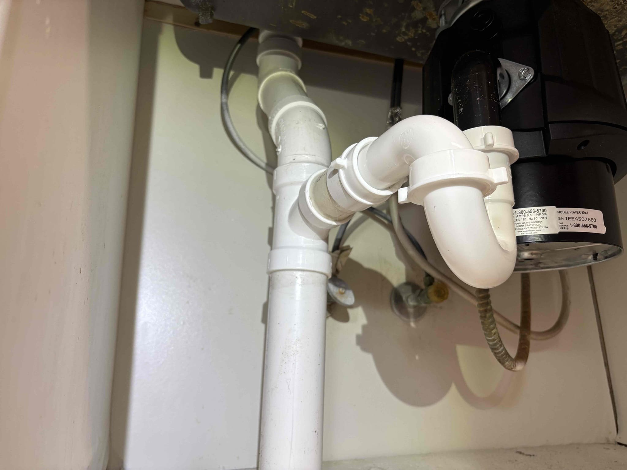 Client called us out due to a sewage backup at the far end of home in the laundry room, up out of that laundry room toilet. While we were there client asked us to also take care of an old and rusty garbage disposal, and also an abandoned drain pipe, open and just stubbed up through the floor. 

We installed the new customer supplied garbage disposal in kitchen and cut out that abandoned pipe. We also abandoned the old cast iron kitchen waste arm in the wall that the kitchen was still draining in to and stubbed up new pvc pipe through same hole, added a tee and an air admittance valve under the sink for that fixtures vent. Also added new tubular drain ptrap.

We pulled the laundry room toilet as the entire sewage system was full of water and ran camera and drain machine as far as I could. Couldn’t get far enough, so. We had to get some garbage/plastic bins, lightly unscrew 2 cleanout caps In different areas, and let the system completely drain down into the bins so we could get closer. 