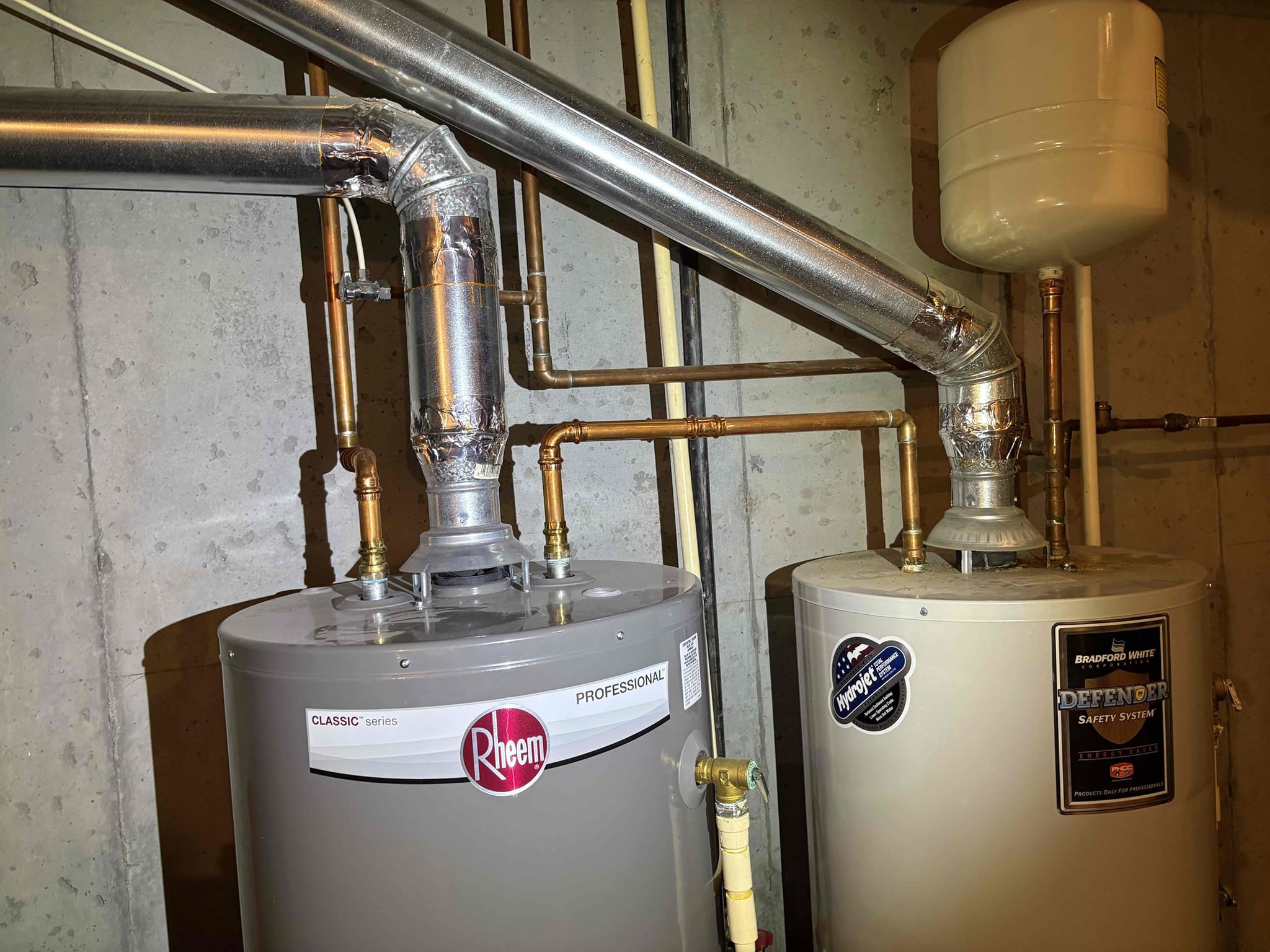 Client called us out due to one of the dual 50 gal nat gas water heaters leaking from a couple different places. The other heater was replaced in 2022. They were originally piped in series, which has one heater that does most of the work and the other is basically a storage tank. We replaced the failed heater with new Rheem pro series 50 gal nat gas water heater in a pan and up to code with properly supported 5 gal thermal expansion tank. We piped both water heaters in Parallel, which makes both water heaters take up an even amount of work. Added new check valve on cold feed added new tee for recirc line and new tee for expansion tank then our tee for the 2 water heaters, all in new copper pipe. Tied the hot side in as necessary with copper and fittings as well. Hooked the gas up and turned on to test. Both units are running as they should. 

We were out here in Feb. 2025 and replaced the failed pressure reducing valve. While doing my inspection I checked the water pressure and it was 