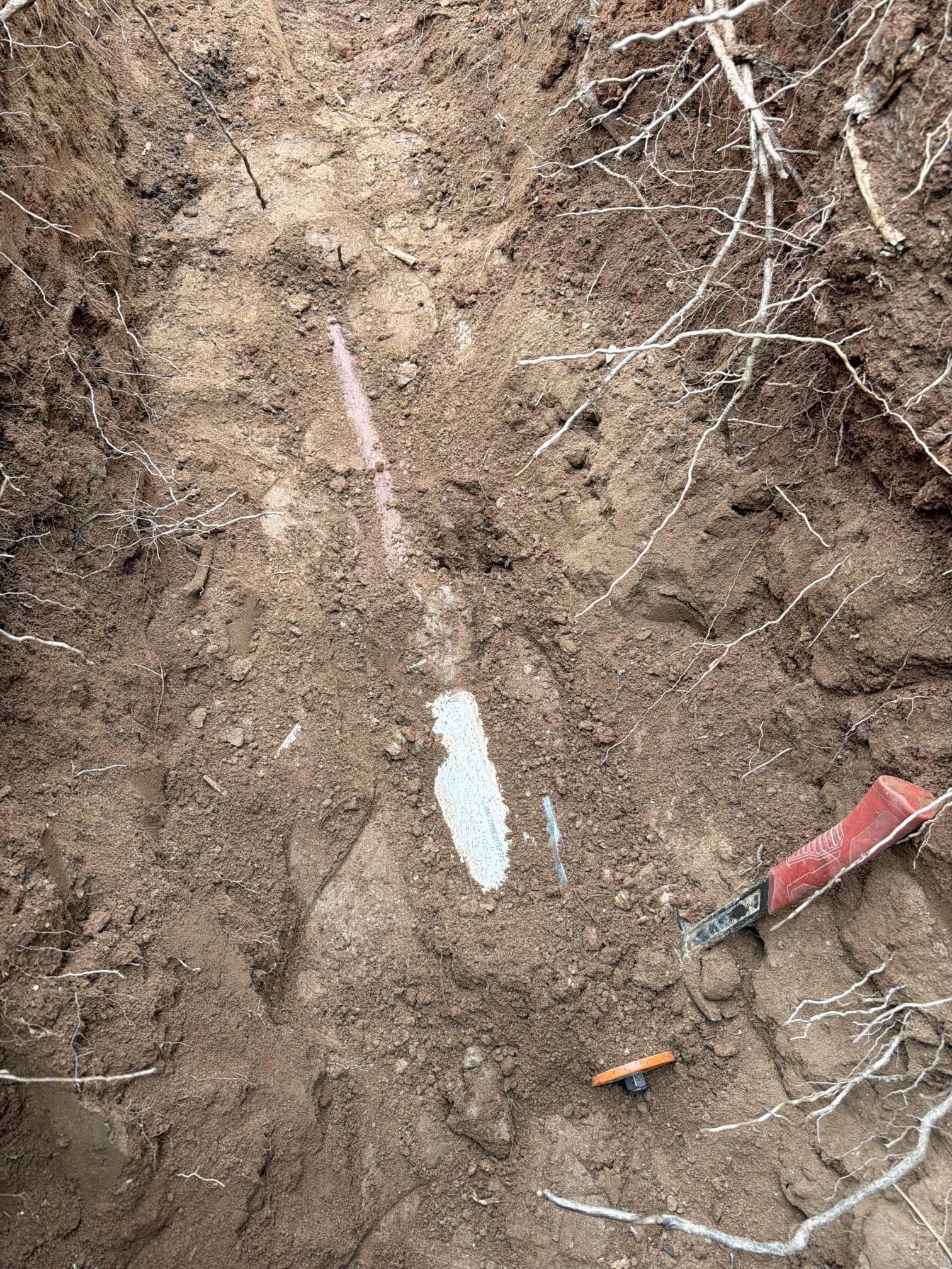 




Customer contacted us due to toilets making bubbling noises and slow to flush. During the initial visit on January 7, 2026 a diagnostic evaluation was performed. We found that the front cleanout was completely full of water, indicating the main sewer line blockage. This finding was confirmed via camera inspection. Although the camera was  underwater throughout inspection, we were able to determine that there was an obstruction approximately 50 feet out. The location was marked with paint for reference. 


Sewer equipment was then ran to attempt to clear the blockage. But the line could not be successfully cleared. Customer was informed that the next recommended step would be to excavate and expose to identify the cause and perform spot repair. Customer approved the recommendation.


We returned the following day and excavated the line at the mark location. Exposing the pipe, we discovered multiple failures, extending an additional 10 feet beyond the original dig area. Customer was