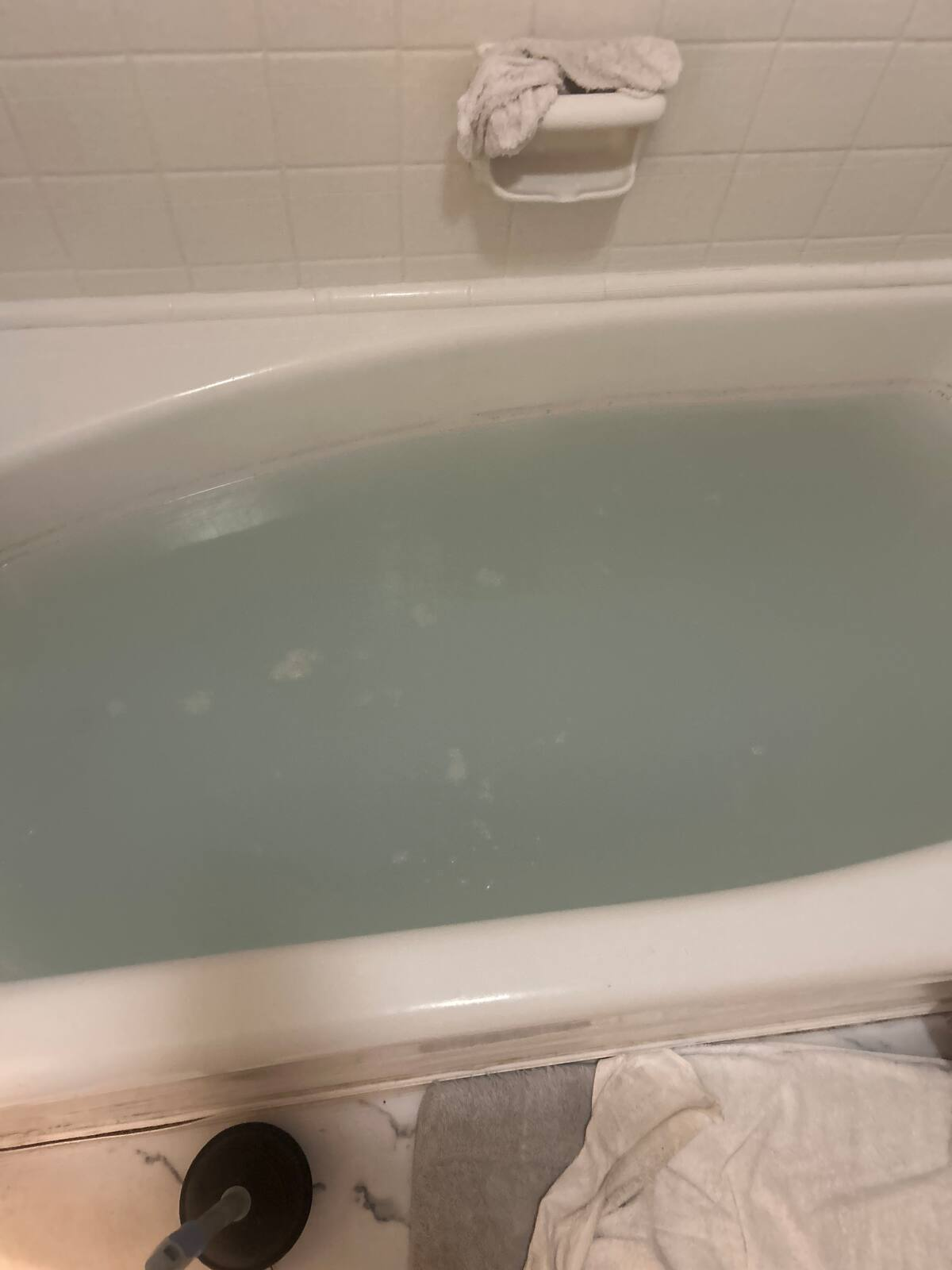 Call for tub not draining. 

Toilet and  vanity draining without issue.

Used small cable to clear blockage. Some hair returned on cable but otherwise blockage did not appear to be caused by misuse or neglect. PVC drain line present in yard, water flowing freely. Some cast iron may remain under house, which could have caught hair over time. 

Ran water for approximately five minutes after clearing. Cleaned site and work space.