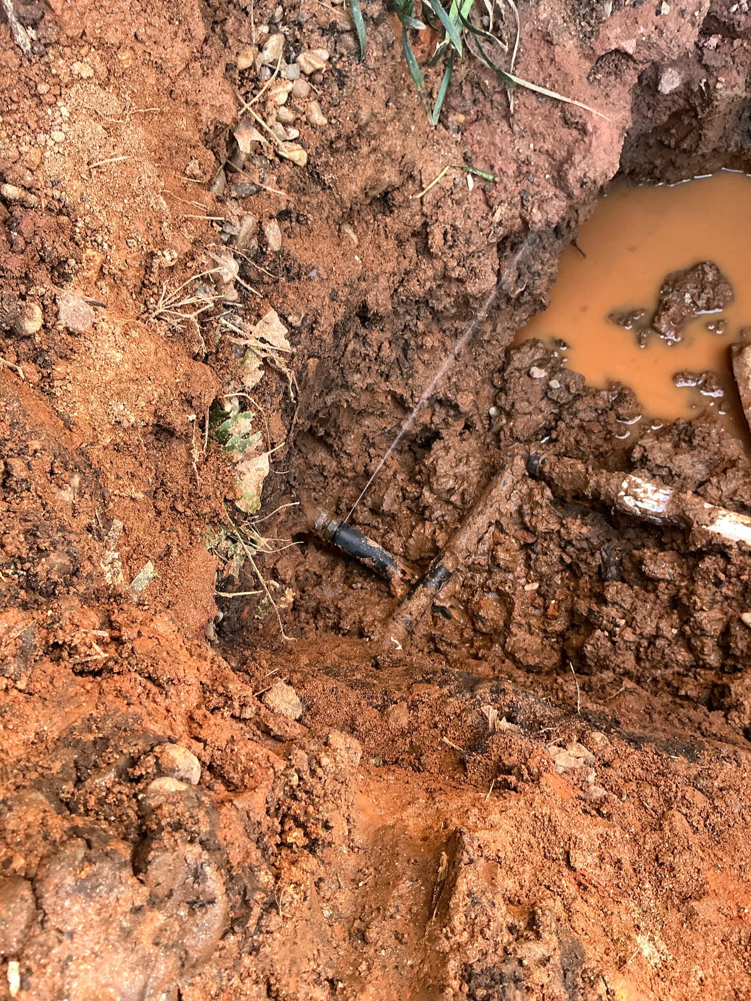 Client called us out due to their guys while working finding/hitting the main water line that had a pinhole in it right at the bend in the pipe before going into the home. There was just not enough pipe sticking out to be able to fix it just outside, so we removed that pipe from the foundation, drilled the hole out, then inserted the new type L copper pipe with tape around the pipe as a sleeve. Connected the copper to the 3/4” black poly outside and then reconnected to the copper inside. Did have to cut small hole in basement Sheetrock to do repair, but was able to put an access panel over the hole. Hydraulic cemented both inside and out after testing. Also backfilled hole for client as their client was worried about the water line being exposed in the cold temps. 

They are good to go, no more leaks. 

Bill out. 