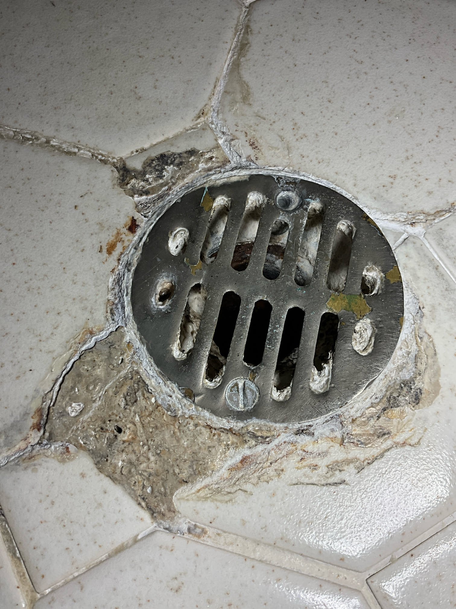 Call for leak in ceiling in dining room.

George stated that the leak has occurred sporadically over a year. He also stated that he has used small auger or retrieval tool to remove blockages from this shower in the past when it was draining slowly, including recently. After he removed hair the ceiling stopped dripping. 

When I inspected the master shower I found that the waste line and tile shower line are in poor shape. It appears that the seal between the shower and waste line is bad. Due to the nature and condition of the shower pan and tile, it will likely need a new shower pan. 

Today repairs were declined, and George wanted an opinion on what would cause this type of damage in order for them to decide which route to take for repairs and replacement.