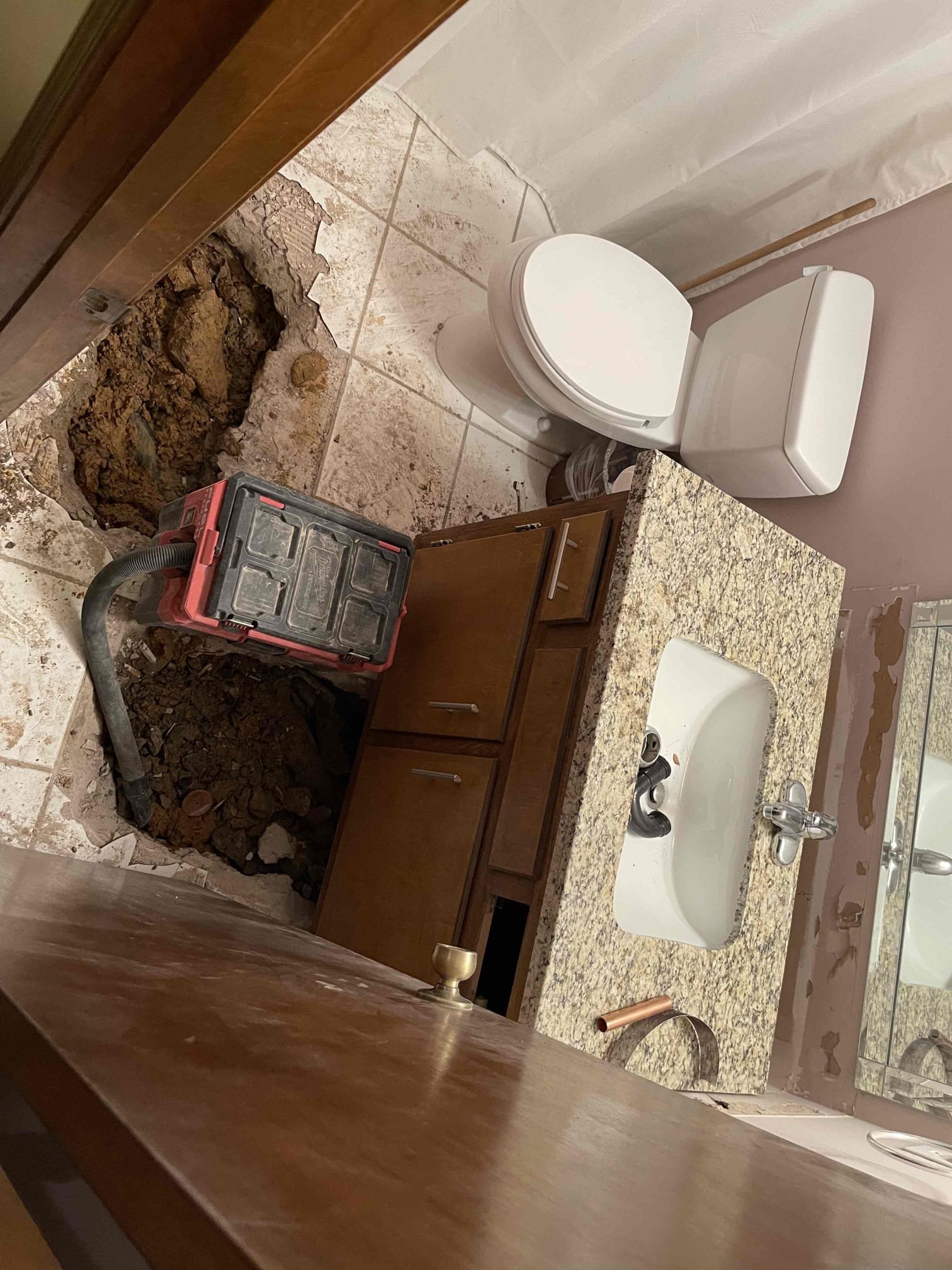 Came out for a high water bill. Met with homeowner who described what was going on. We confirmed there was a leak at the meter. Shut main shut off before the PRV and confirmed the leak stopped, indicating leak was somewhere inside the home. Used leak detection equipment and isolated point of leak to underneath the downstairs bathroom floor. Received approval to jackhammer the slab and dig down to the line. First spot we found the pipe but not the leak. Was getting a strong signal with the leak detection under the vanity. Removed the vanity and jackhammered underneath, no sign of the leak. We realized the signal we were getting with leak detection equipment was due to the leak under the slab spraying onto the drain line which was echoing under the slab and giving false positives. Followed pipe and broke another hole into the slab in front of the toilet. We were able to locate leak on a 3/4 copper water pipe, leak was due to corrosion in the side of the pipe. Cut out leaking sectioned an