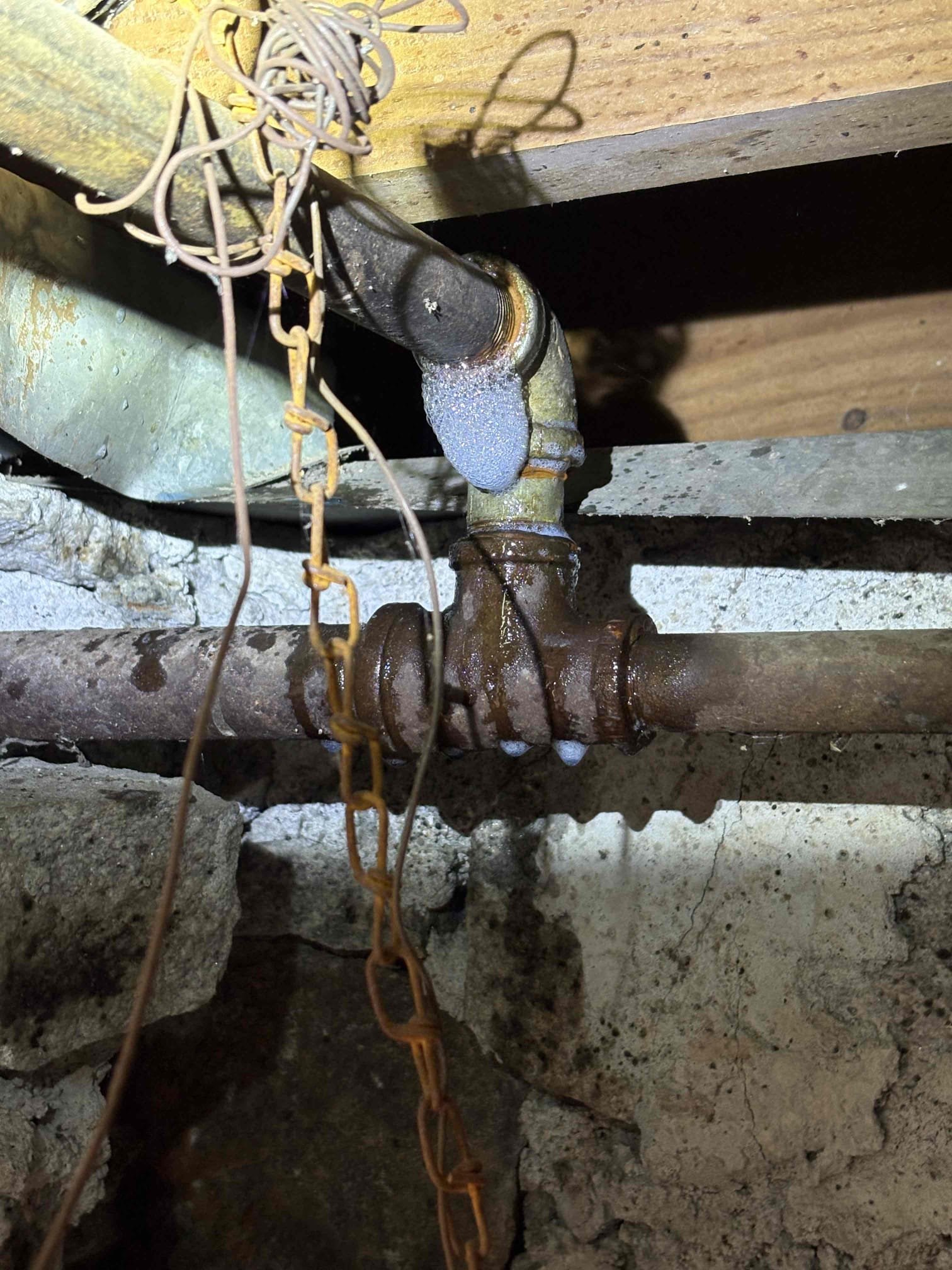 Client called us out due to their drain line backing up on left side of home. After some investigation, I discovered that every bit of the pvc drain work in that section of crawlspace is incorrect. Also was able to see the main sewer line outside is still cast iron pipe. Clients system was only backing up when the new washing machine was ran. This makes sense as there is a blockage, whether it’s roots in the line or a collapsed pipe, and the fixtures that don’t put out a lot of water into drain system will not fill the pipe up and slowly drain through and not cause a backup, but when high volumes of water are put down the system is backs up into the shower. More than likely there is a blockage in the main cast iron line whether out in the yard or still in crawlspace we do not know. 

When we opened door to other side of crawlspace, I instantly smelled nat gas. There was some rusty gas pipe overhead tying into the main feed line. We turned gas off and repaired that leaking section of ga