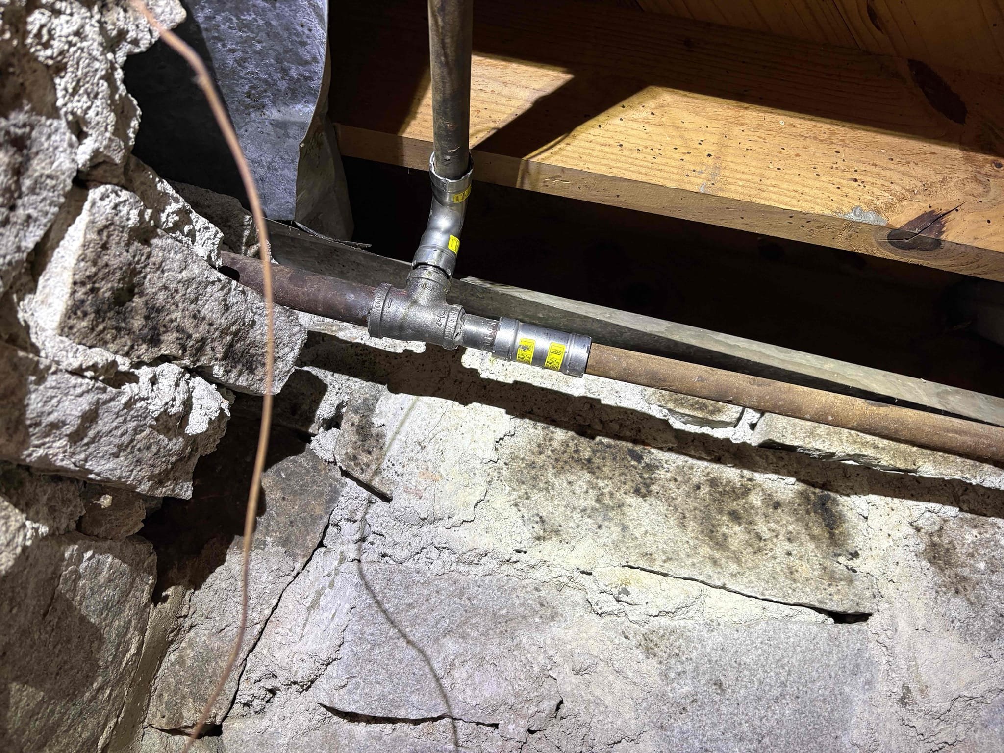 Client called us out due to their drain line backing up on left side of home. After some investigation, I discovered that every bit of the pvc drain work in that section of crawlspace is incorrect. Also was able to see the main sewer line outside is still cast iron pipe. Clients system was only backing up when the new washing machine was ran. This makes sense as there is a blockage, whether it’s roots in the line or a collapsed pipe, and the fixtures that don’t put out a lot of water into drain system will not fill the pipe up and slowly drain through and not cause a backup, but when high volumes of water are put down the system is backs up into the shower. More than likely there is a blockage in the main cast iron line whether out in the yard or still in crawlspace we do not know. 

When we opened door to other side of crawlspace, I instantly smelled nat gas. There was some rusty gas pipe overhead tying into the main feed line. We turned gas off and repaired that leaking section of ga