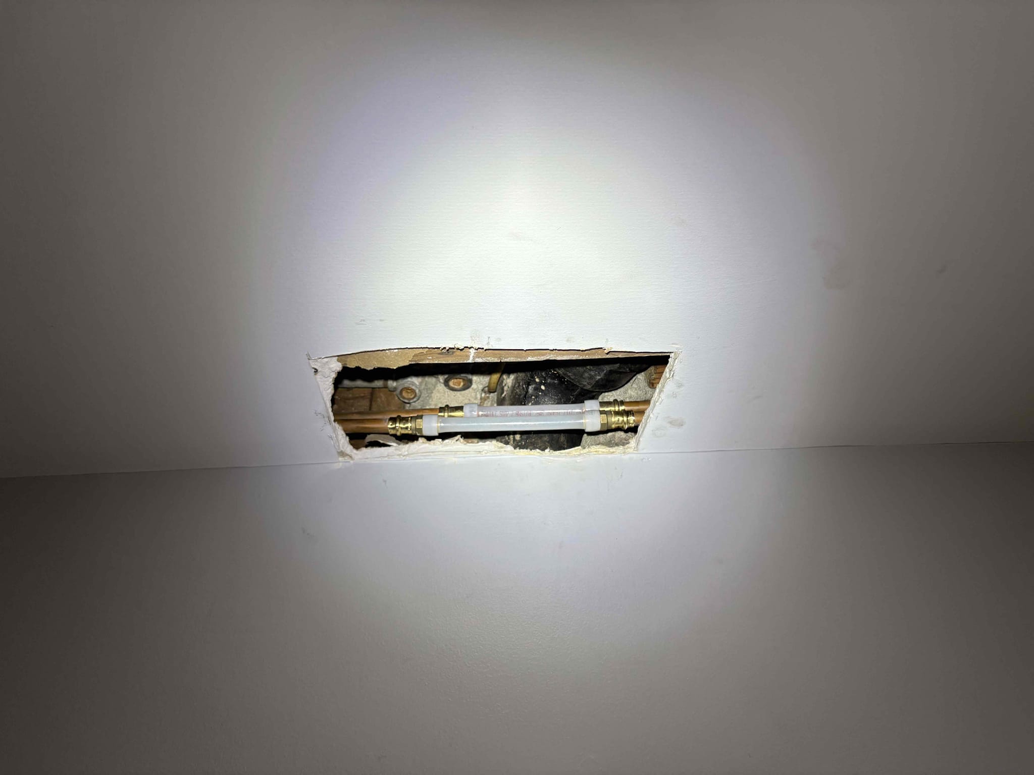 Called out today due to a small leak staining the kitchen ceiling, with the bathroom right above it. The stain was directly beneath the toilet and that drain pipe is cast iron. After some investigation, realized the toilet was not even secured to the floor and it was very wobbly. When we pulled the toilet up the toilet flange actually came up with the toilet which it is not supposed to do. To get client up and running we installed new mechanical toilet flange and secured to floor. New wax ring, closet bolts, and supply line, then sat the new customer supplied toilet. After fastening down tested. No leaks. Caulked around the base leaving back 1/3 open so leaks will show at the back if it does leak in the future. 

We did cut out that small section of stained Sheetrock to verify. There’s a couple copper water lines running right there as well. I wiped 1 drop of water off of one of the section of copper pipe but could never make it drip again. As a courtesy we cut out the 2 sections of co