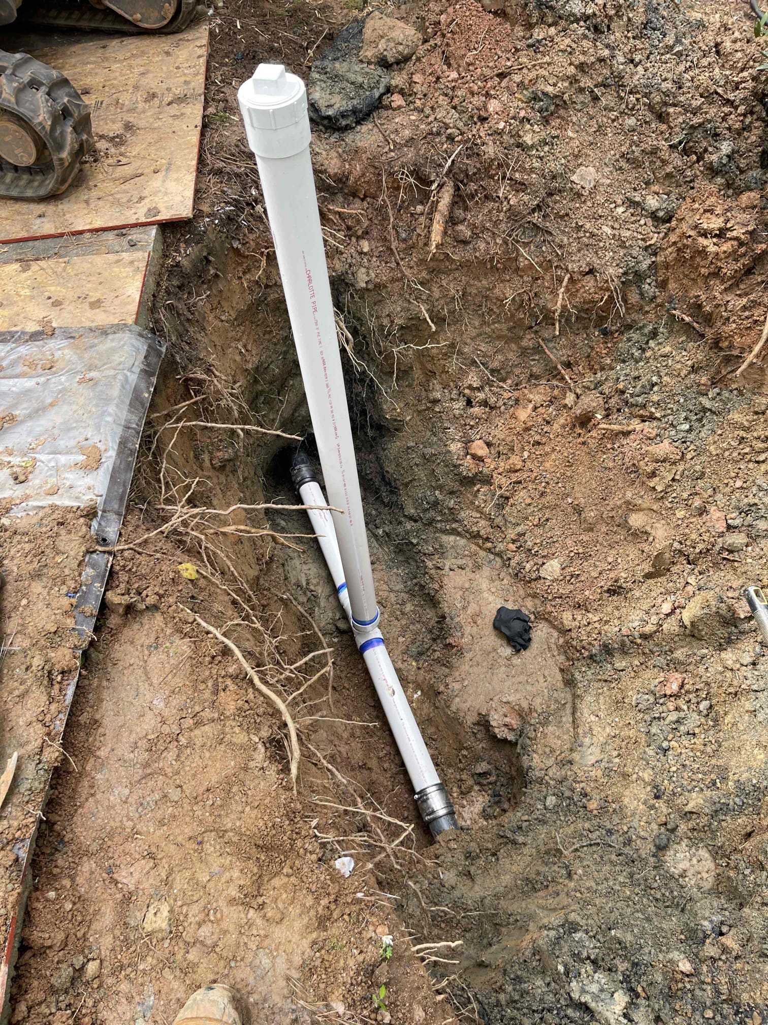 Dug down to pipe where we were seeing sewage come up out of the ground at. Found lots of chunks of asphalt/concrete buried around the pipe. Cleanout branch was cracked, which we took a video of. This was the source of the leak. Cut out the damaged section and replaced with 3” pressure pvc. Ran water inside the home annd tested repair to ensure the line was holding sewage with no leaks. Let the repair sit for 45 minutes while we went annd got more sand to ensure no slow leaks. Encased the shielded fernco’s with hydrostatic foam. Bedded pipe up to 6” above and below the pipe with sand. Backfilled by hand another 1’ of dirt above to ensure no rocks were touching the pipe. Backfilled the rest of the soil, tamping every 12”. Replanted the bushes we removed back in their original locations. No further issue at this time. No warranty on the repair due to it being a lift station ejection line. Homeowner was made aware of this. The break on the pipe was not on the discharge line itself, but on 