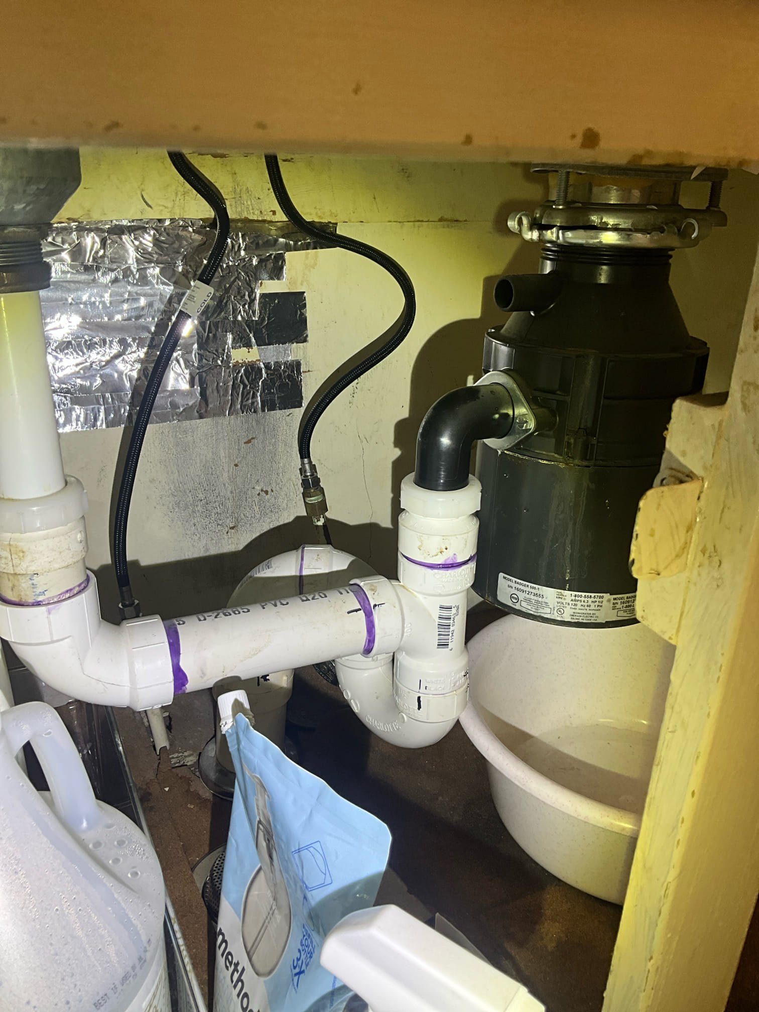 Customer had a garbage disposal that was leaking. Noted to customer that an S trap was present below the sink and doesn’t meet code requirements for the drain. During safety check found that there was two water heaters in parallel. An electric heater for 1999 and a gas water heater from 2023. Recommendations for customer is to replace the garbage disposal, install proper venting for the kitchen drain, and remove the water heater that is 27 years old. The house is a 3 bath house and 50 gallons heater via a gas water heater is sufficient for the home. Customer approved all work but not the membership. Replaced the garbage disposal and install an air admittance valve. Removed the electric heater in the basement and capped the old lines. Made customer aware that the electric heater didn’t have a dedicated breaker. It was labeled under the two pole breaker for the furnace in the box. Recommended customer have electrician remove the water heater electrical line and install proper wire protec
