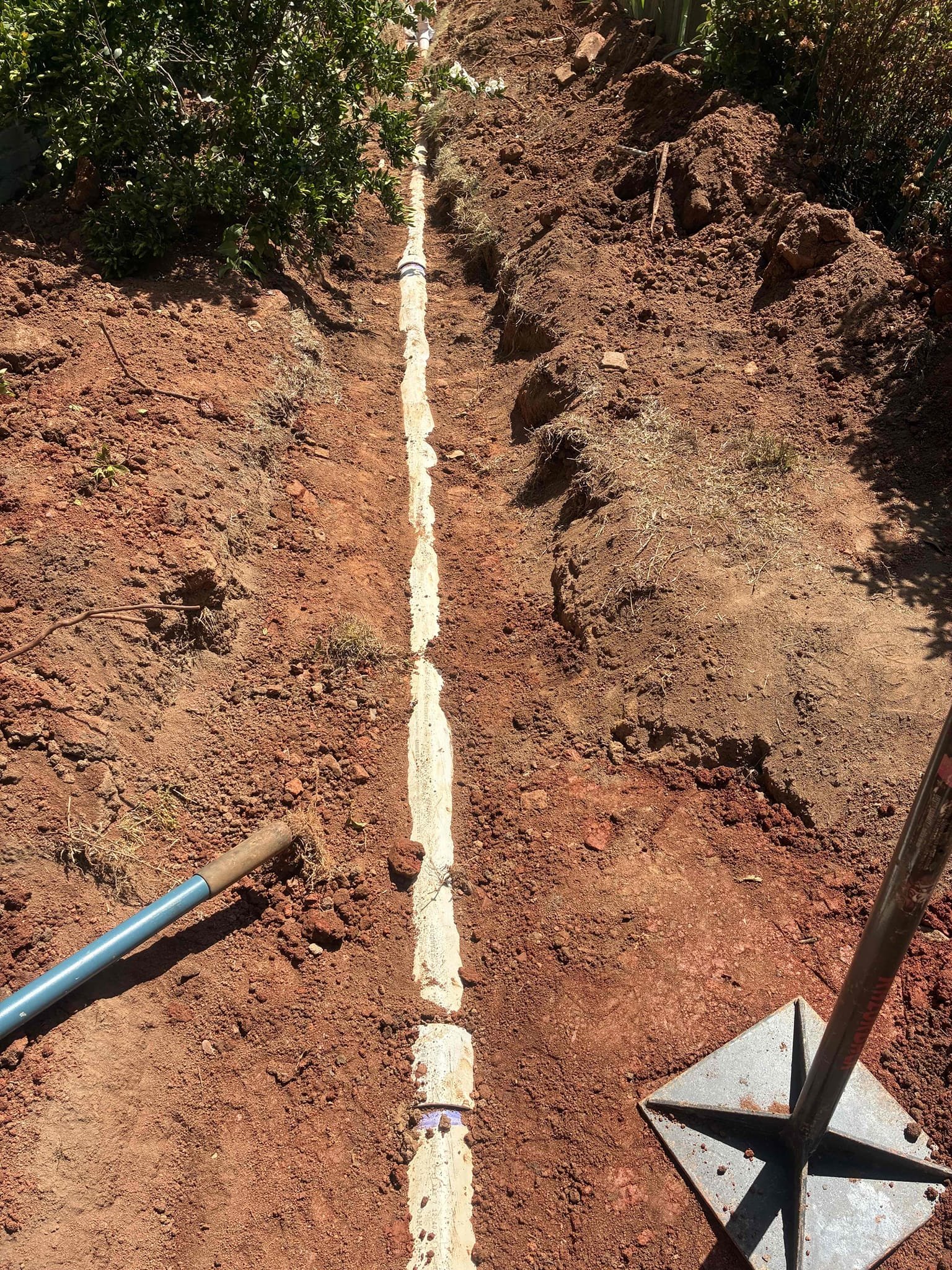 Customer had 6 inch terra-cotta sewer line, broken and separated in yard. Gave quote to replace line with 4 inch PVC all the way to city tap. City came out to install 6 inch clean out at tap and clear line of roots. After city work was done excavated from house to tap in order to install new sewer line. Cut area of sidewalk. Also used existing 6 inch terra-cotta as sleeving to tunnel under retaining wall. Also replaced majority of water service that was removed during excavation. After installing sewer and waterline, checked all areas of work for leaks and proper drainage function. Bedded sewer line and checked various points for proper pitch. Sewer line is ready for inspection. after inspection, will return to backfill trench to rough grade. Not responsible for the put back of concrete for sidewalk. Ran water inside home to check for proper drainage. Make connections to existing line for home and tap with proper connection methods and concrete two in case fittings. Also installed 4 in