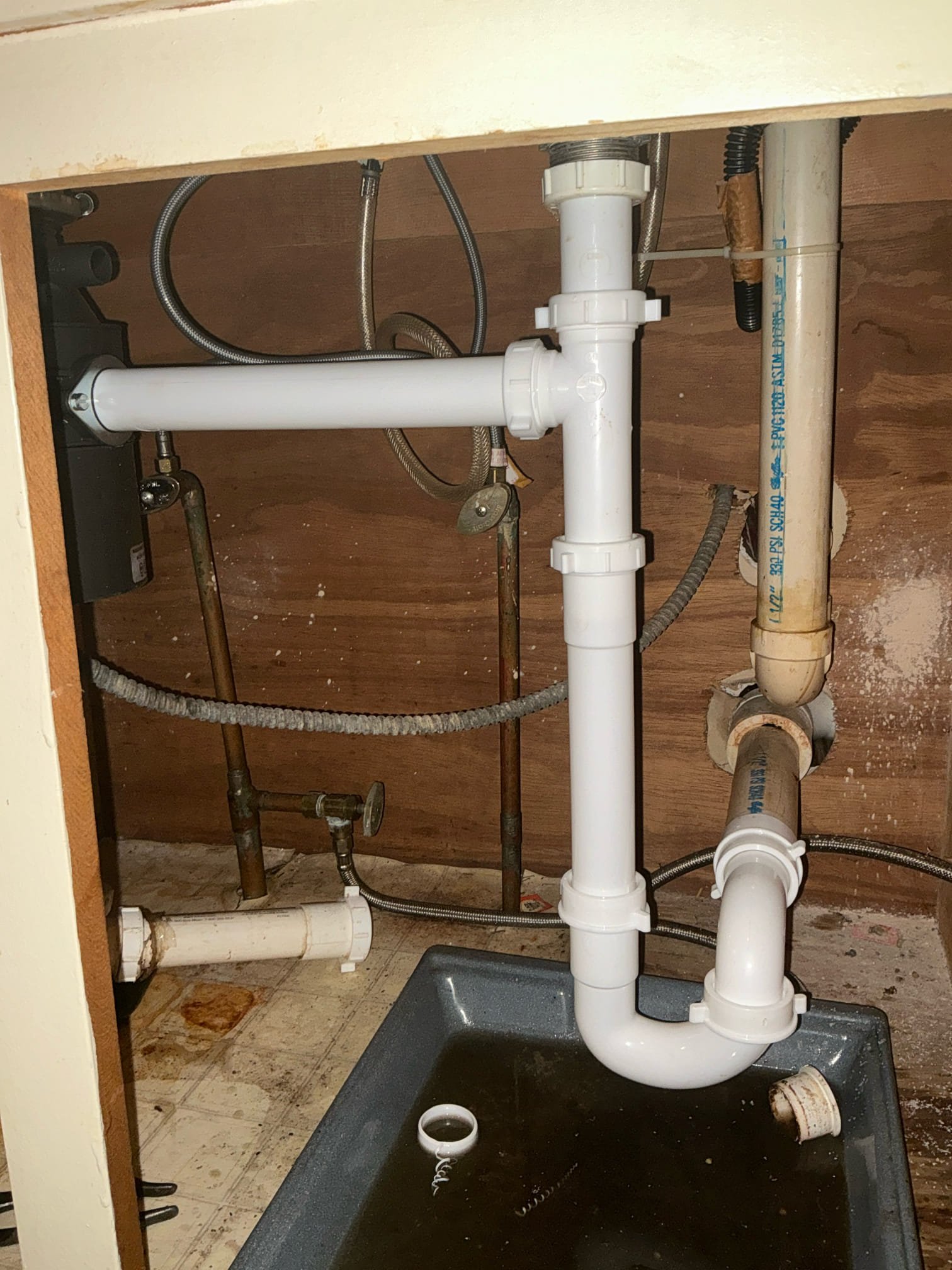 Found kitchen sink drain leaking. Reworked kitchen sink drain in cabinet with new disposal end outlet and p-trap. Filled sink and let drain to test. Left work order.