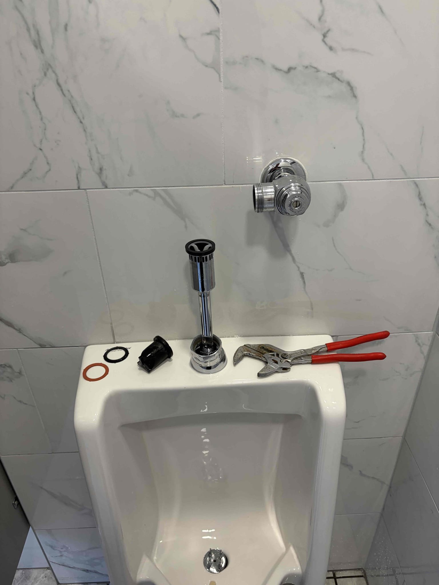 Replace urinal flushometer in men’s restroom 
Auger toilet 

Came out to this commercial property due to a leak coming from the urinal, the urinal was constantly flushing and the toilet was clogged. I used my 6 foot auger to get the toilet unclogged and the toilet is flushing again, I can see the water coming out the clean out outside, additionally we went ahead with the urinal flushometer replacement. Installed a new Sloan 0.5 flushometer 186. I replaced it with a new vacuum breaker and new head unit. Once installed there are no further leaks. Customer is all set at this time of service.