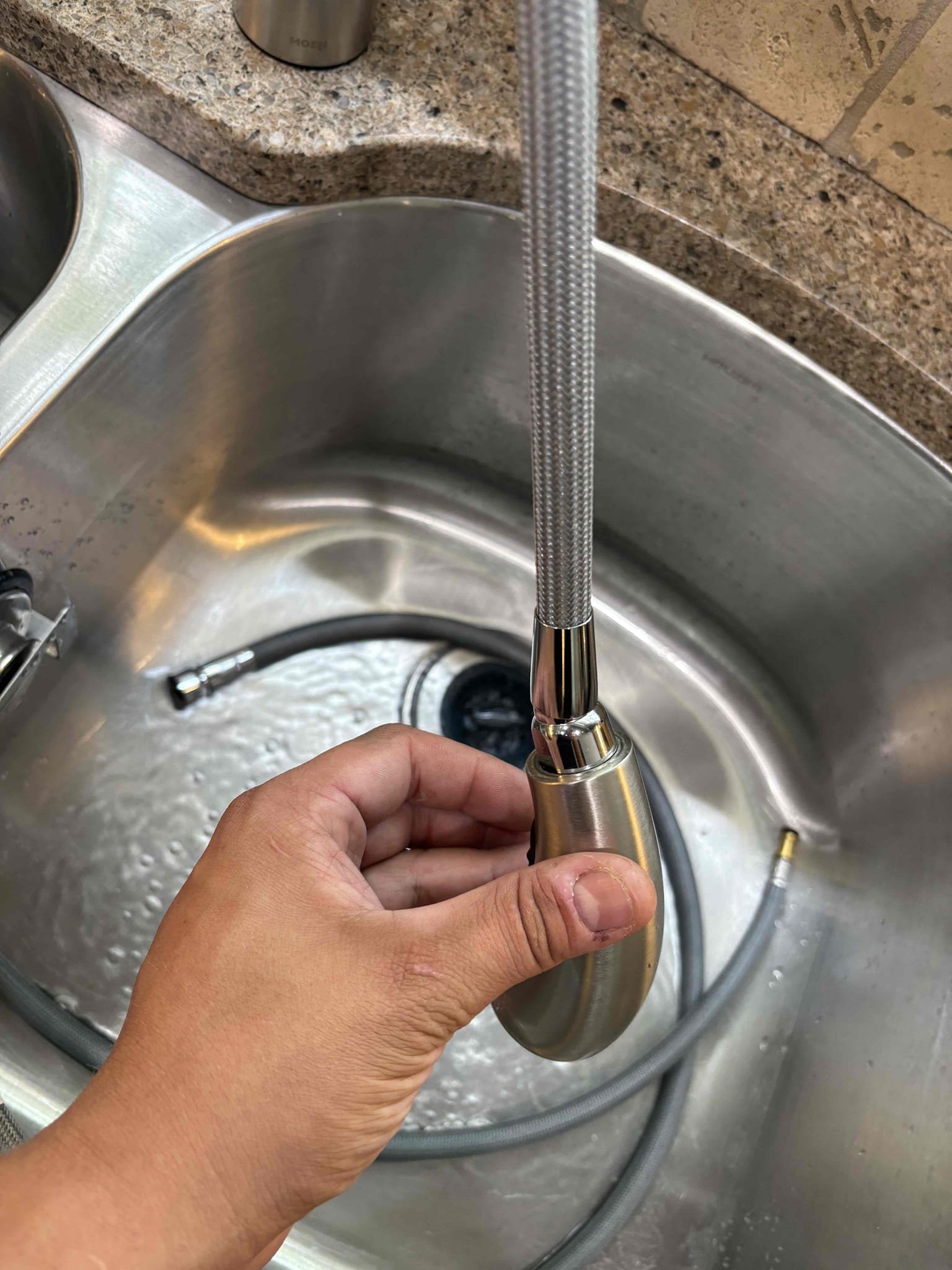 Diagnosed leak at kitchen sink. Found pull out sprayer hose leaking in multiple places. Shut off water to faucet and removed hose. Replaced with new moen replacement hose and tested for proper operation. No leaks found after work completed 