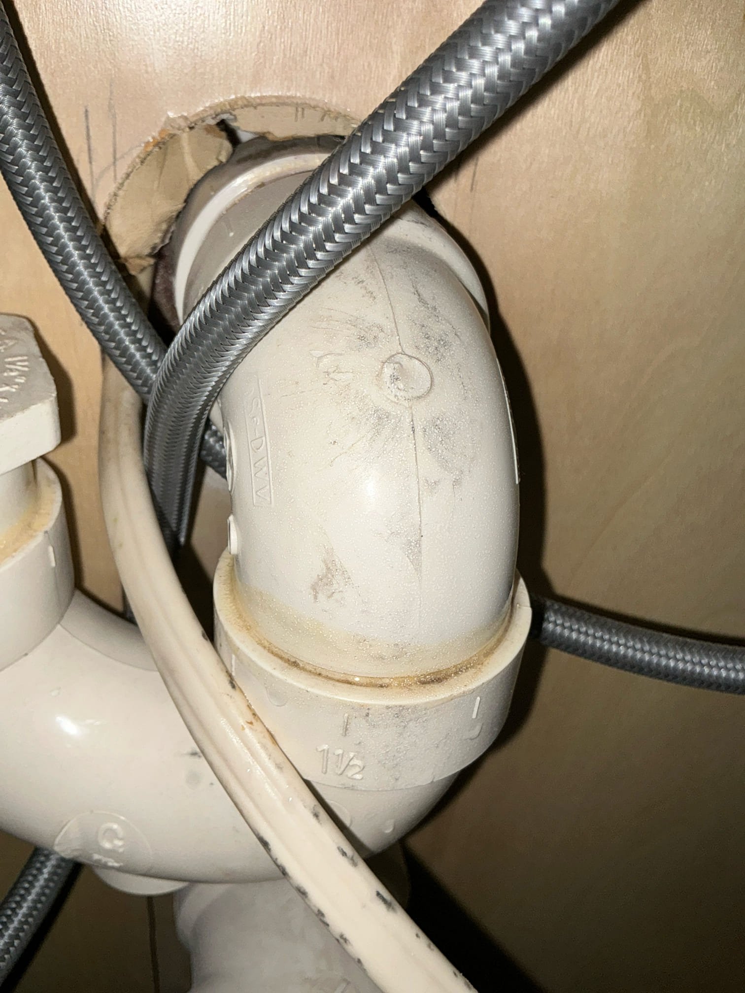 Found leak under kitchen sink on failed glue joint. Leak is from dishwasher discharge. Cut and cap line and route dishwasher line to disposal. Connect and test for proper operation. Clean work space 

Left estimates to replace water heater and hose bib in front