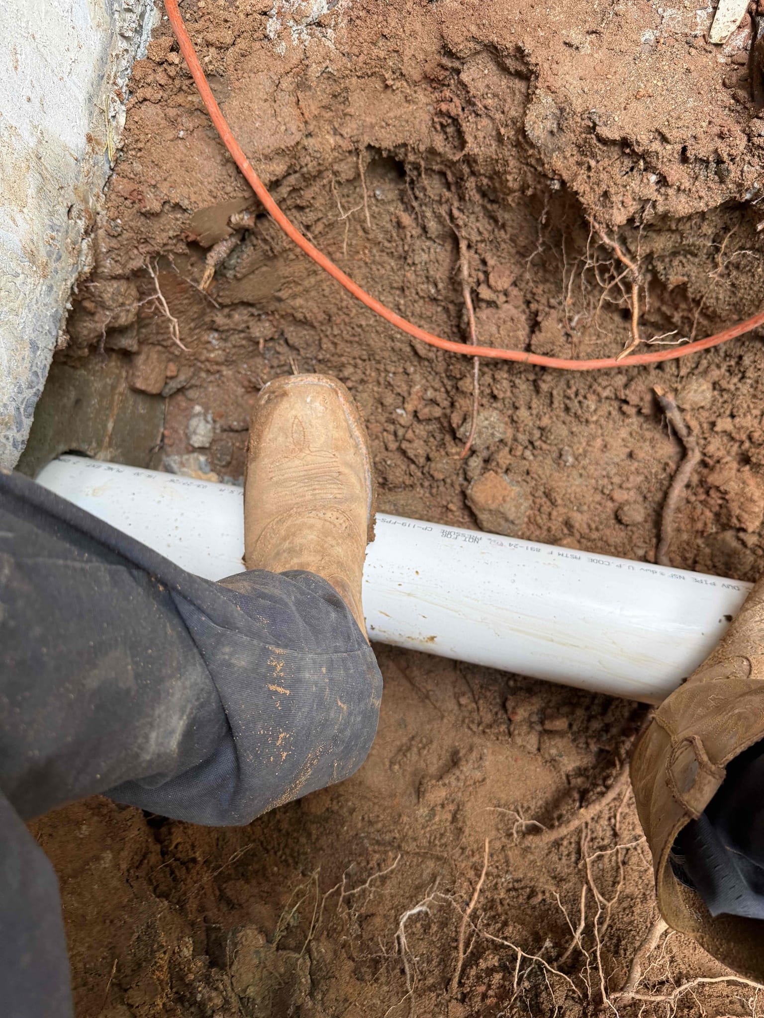 Returned to reroute sewer line to the back of the house and run a new sewer line down to the city tap. Had concrete guys come out and cut back porch as well as the laundry room up to access old sewer cast iron sewer line. Re routed sewer line out of the back of the house added a new penetration to the wall. Ran sewer line down back yard and around to connect back to the city’s tap. Added a two way cleanout right past the back porch and a cleanout at the city line. Flushed all toilets and ran sinks/showers to check for leaks and found no leaks. Bedded in sewer line and made sure it has proper slope. Sewer line is flowing properly and no leaks upon departure 