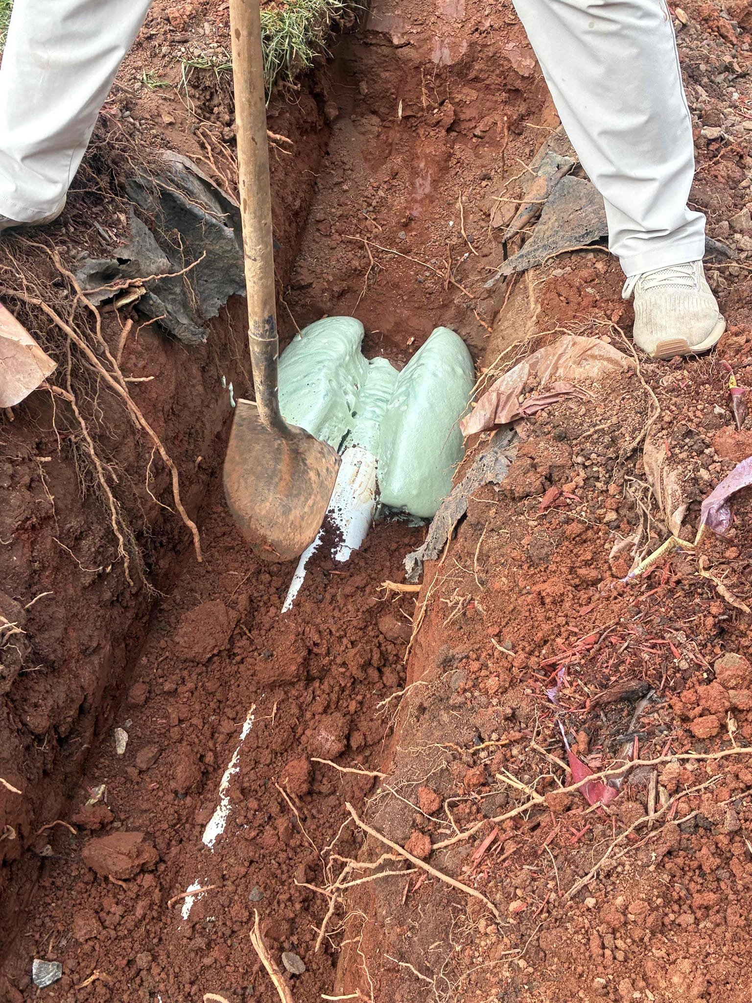 Customer had blockage when I arrived. Ran machine through cleanout to clear line then ran camera to determine area of blockage was affected by roots entering a section of cast-iron piping. Gave customer option to replace section from PVC back to asbestos piping. After approval dug down approximately 3 to 4 feet and replaced a 10 foot section of piping with 4 inch PVC. Connected PVC with approved material methods and secured with quick setting mix after work was complete backfilled section to rough grade and put back partial landscaping to the best of my ability. Later, finding kitchen sink still not draining properly as courtesy ran small snake a short distance to help issue informed customer issue could return and we will need to further investigate to address issue.